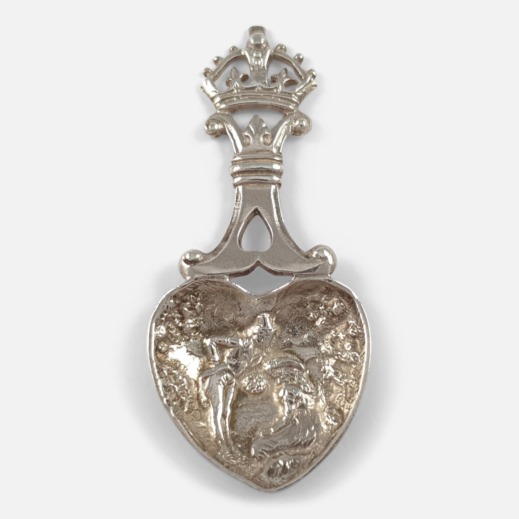 A Victorian Scottish sterling silver tea caddy spoon. The caddy spoon is crafted with an openwork crown finial, and a heart-shaped bowl, with a courting couple in relief. It was made by the silversmith J.M. Talbot, and hallmarked Edinburgh,