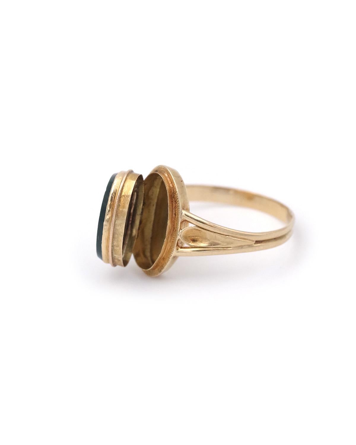 Bague chevalière victorienne en or 18 carats avec médaillon en pierre de sang. Bague médaillon sertie d'une plaque ovale en pierre de sang qui s'ouvre pour dissimuler un petit objet sentimental. Ils sont également appelés 