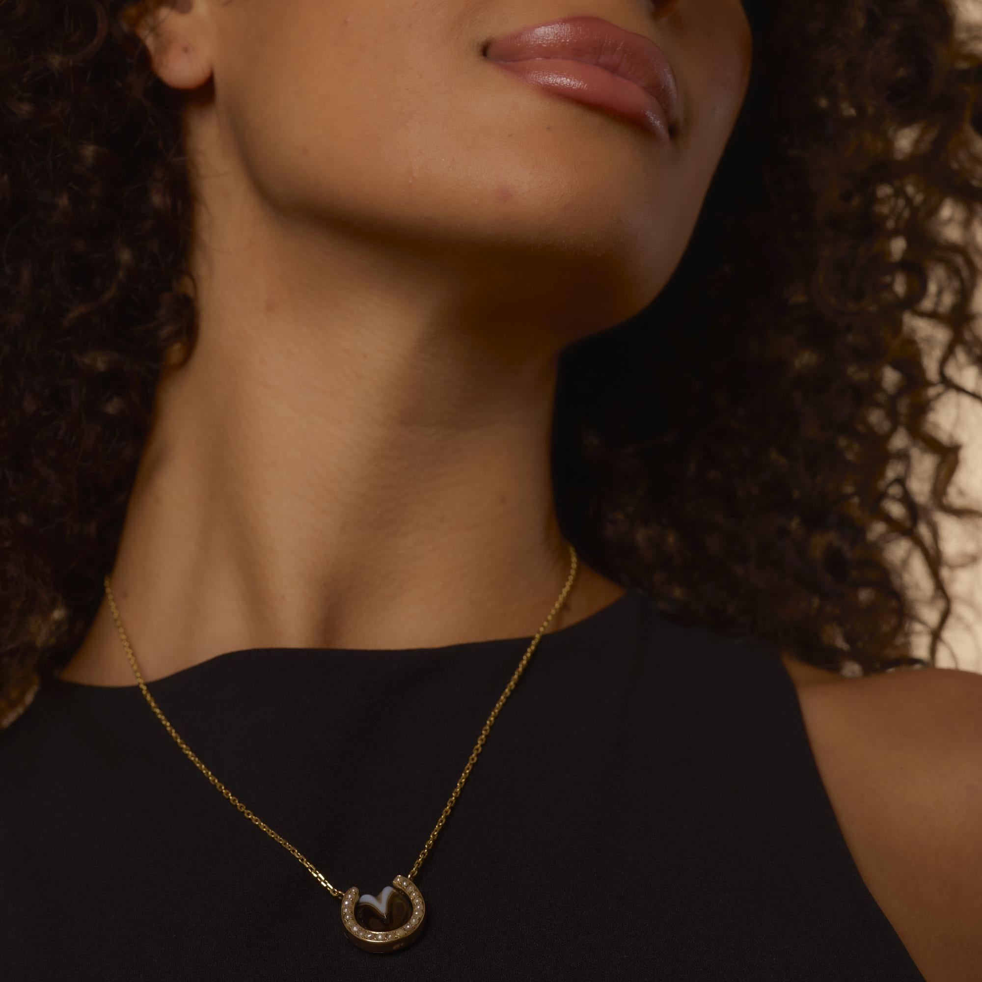 This antique Victorian necklace features a beautifully preserved 3/4 inch pendant adorned with twenty-one luminous seed pearls, each approximately 1.50 mm in size. Set in a warm blend of 14k yellow and rose gold with delicate enamel work, the