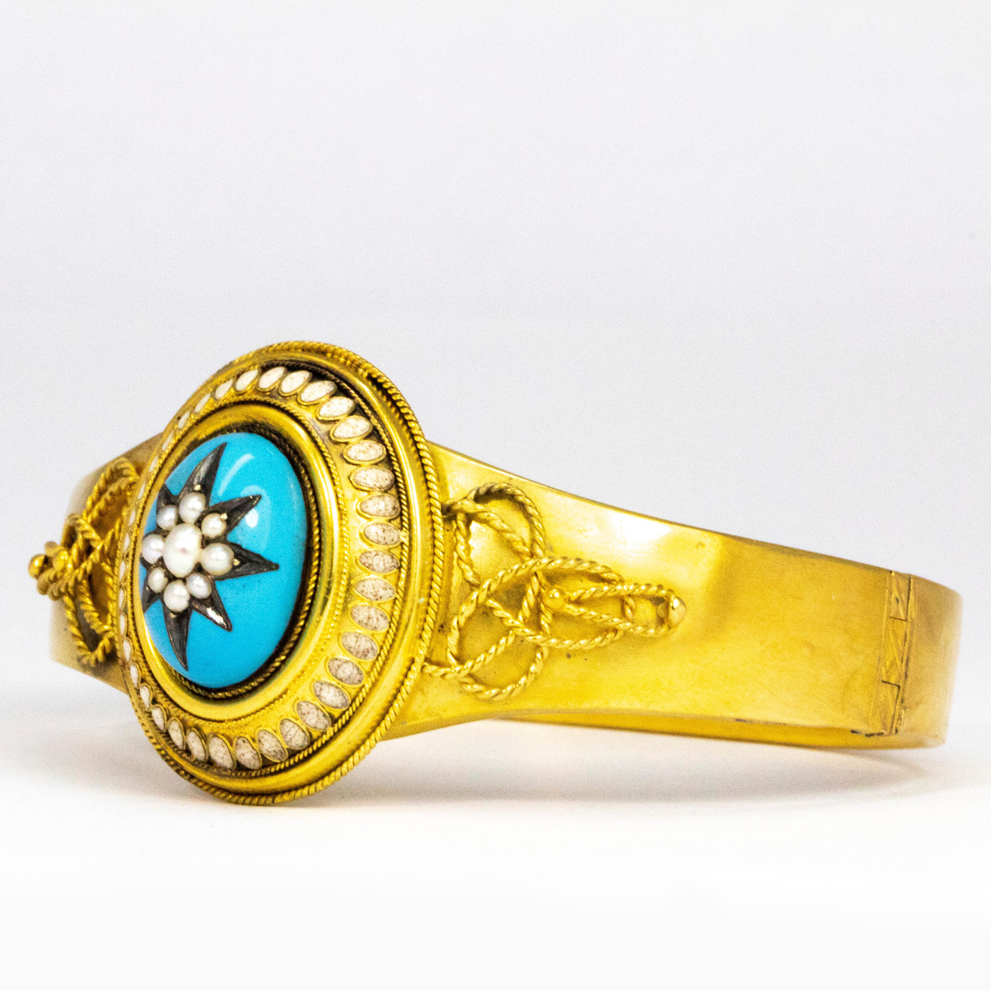 The pop of the blue enamel is stunning next to the bright yellow gold. At the centre of the blue enamel is a carved star encrusted with Perls and the frame around the outside also features a pearl halo. The shoulders also have gorgeous fine chain