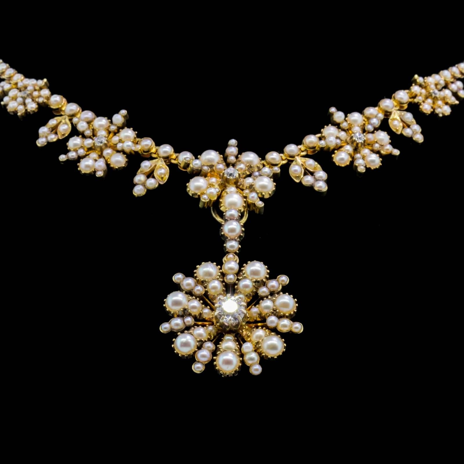 A coveted Victorian beauty!  This lovely 18KT yellow gold Seed Pearl Necklace was created in two sections. One with five Seed Pearl florets centering an Old Cut Diamond, and the second section is a detachable, dangling larger Seed Pearl floret,