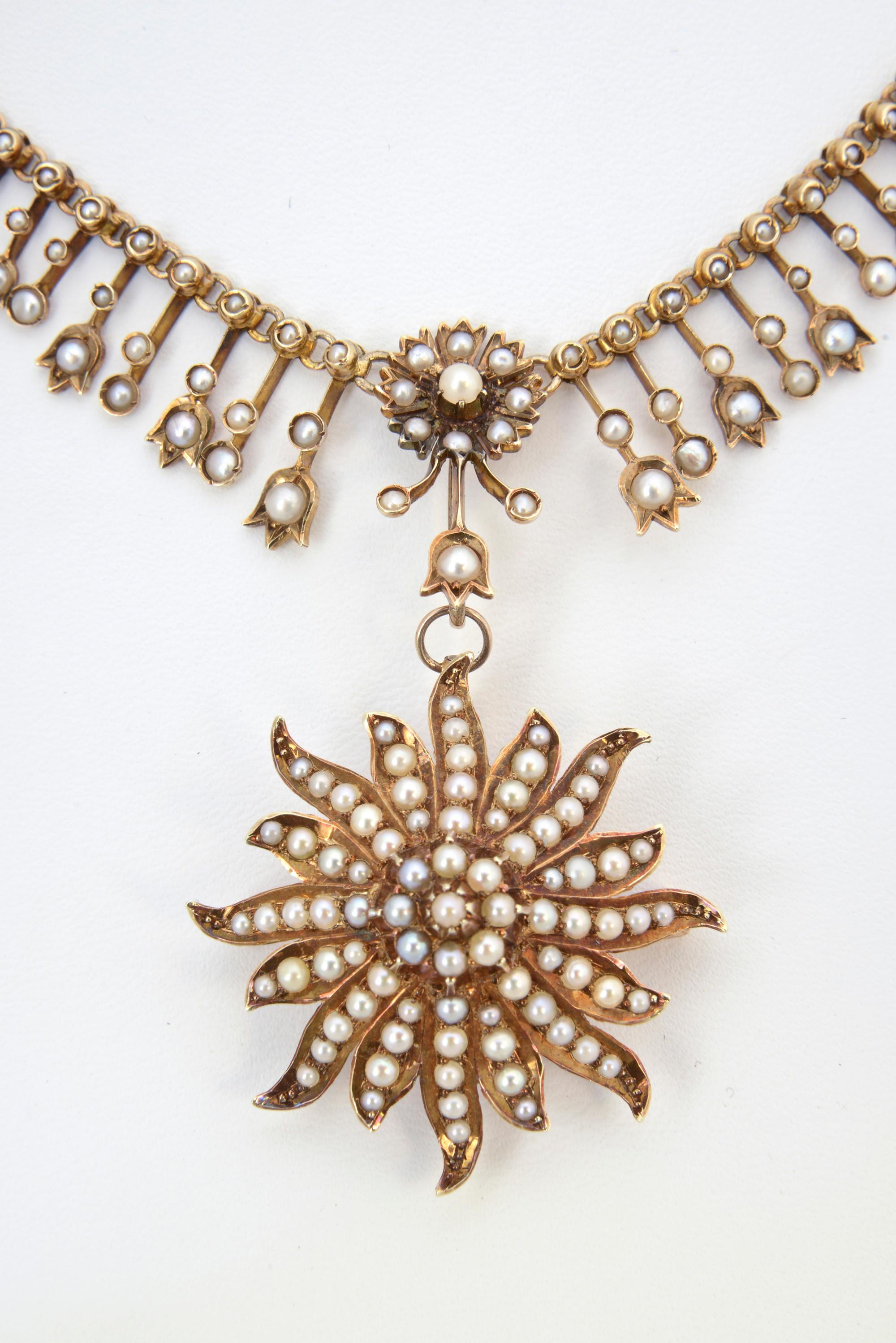 Late Victorian 14K gold and seed pearl fringe necklace. The graduated fringe has floral accents. Starburst pendant/brooch is detachable. The back of the necklace is a rope chain. Pendant/brooch, 1.5