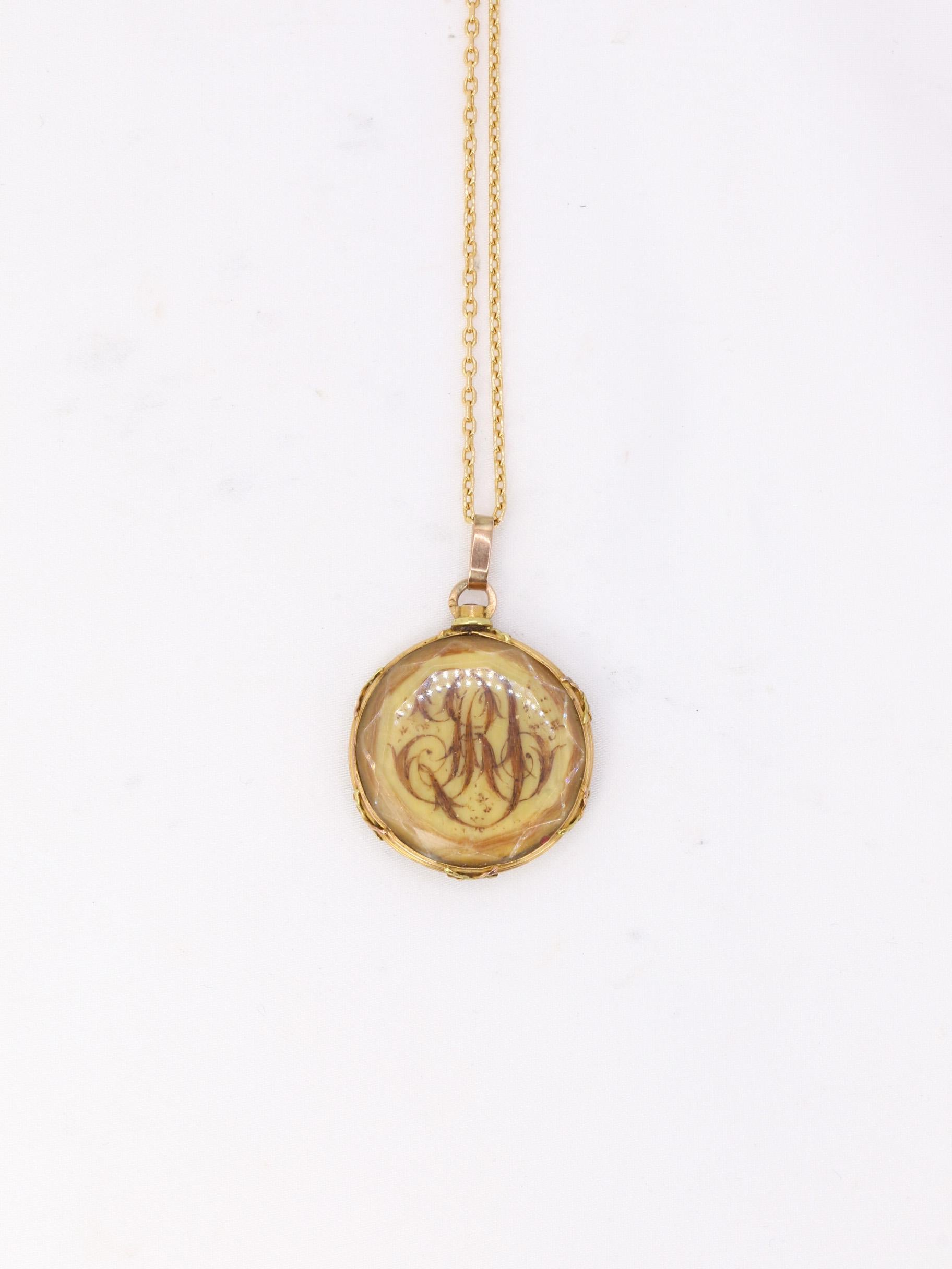 Round 18k (750°/°°) yellow gold pendant featuring a 4-leaf clover motif in hair on one side and a monogram in hair with the letters R and G on the other.
This type of sentimental or mourning jewelry was fashionable from the 1820s until the Second