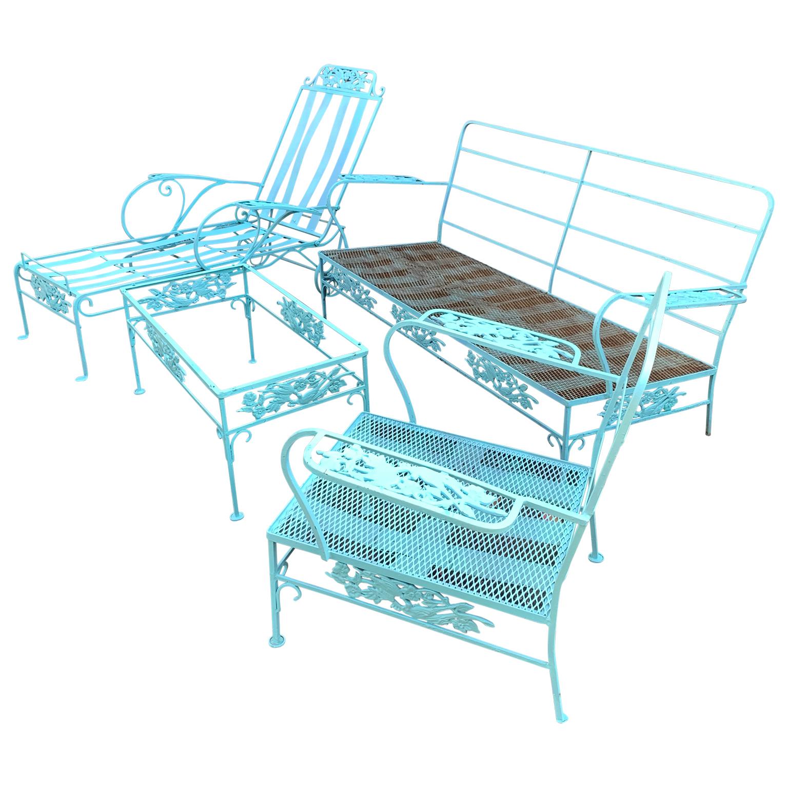 Turquoise painted iron garden patio cocktail table, lounge chair, two person sofa and armchair. This late Victorian set is featuring scrolled iron corners that conjoin and taper ending with flat round feet. The frieze is decorated with birds and