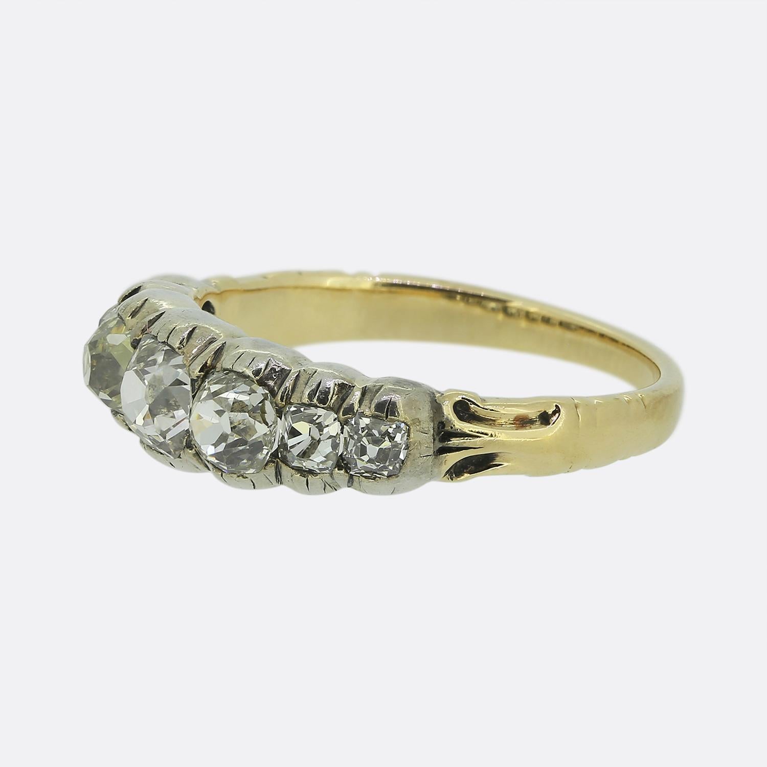 Here we have a beautiful diamond ring dating back to the early Victorian period. The band of the ring is crafted in 18ct yellow gold and the face features seven old cut diamonds that sit in silver cut down collet mounts. This style of ring is rare