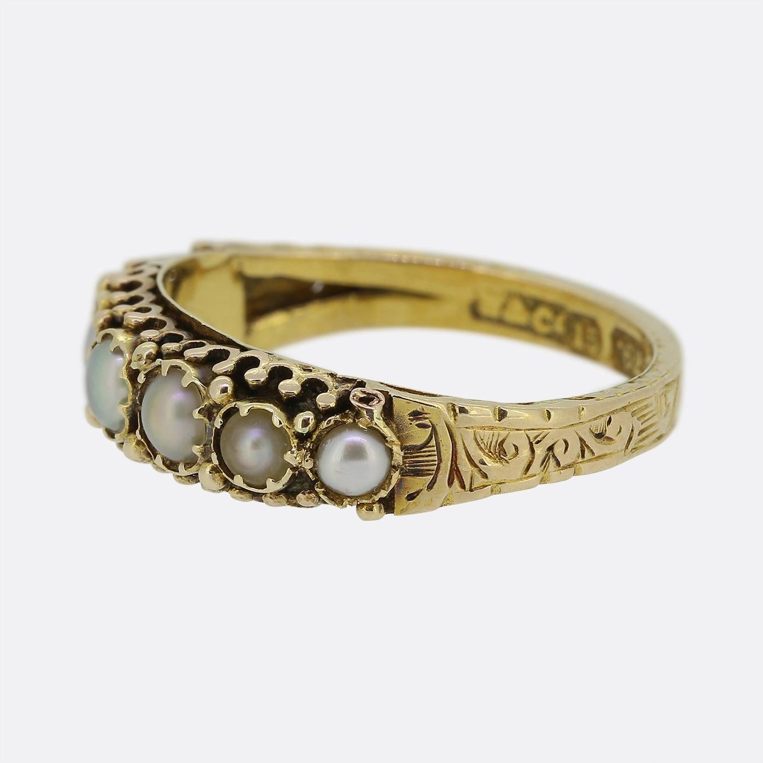 Hier haben wir einen charmanten Ring mit sieben Steinen aus der viktorianischen Zeit. Eine Fassung aus 15 Karat Gelbgold beherbergt sieben runde Naturperlen, die einzeln in einer einzeiligen Formation auf der Vorderseite gefasst sind. Dieses Stück
