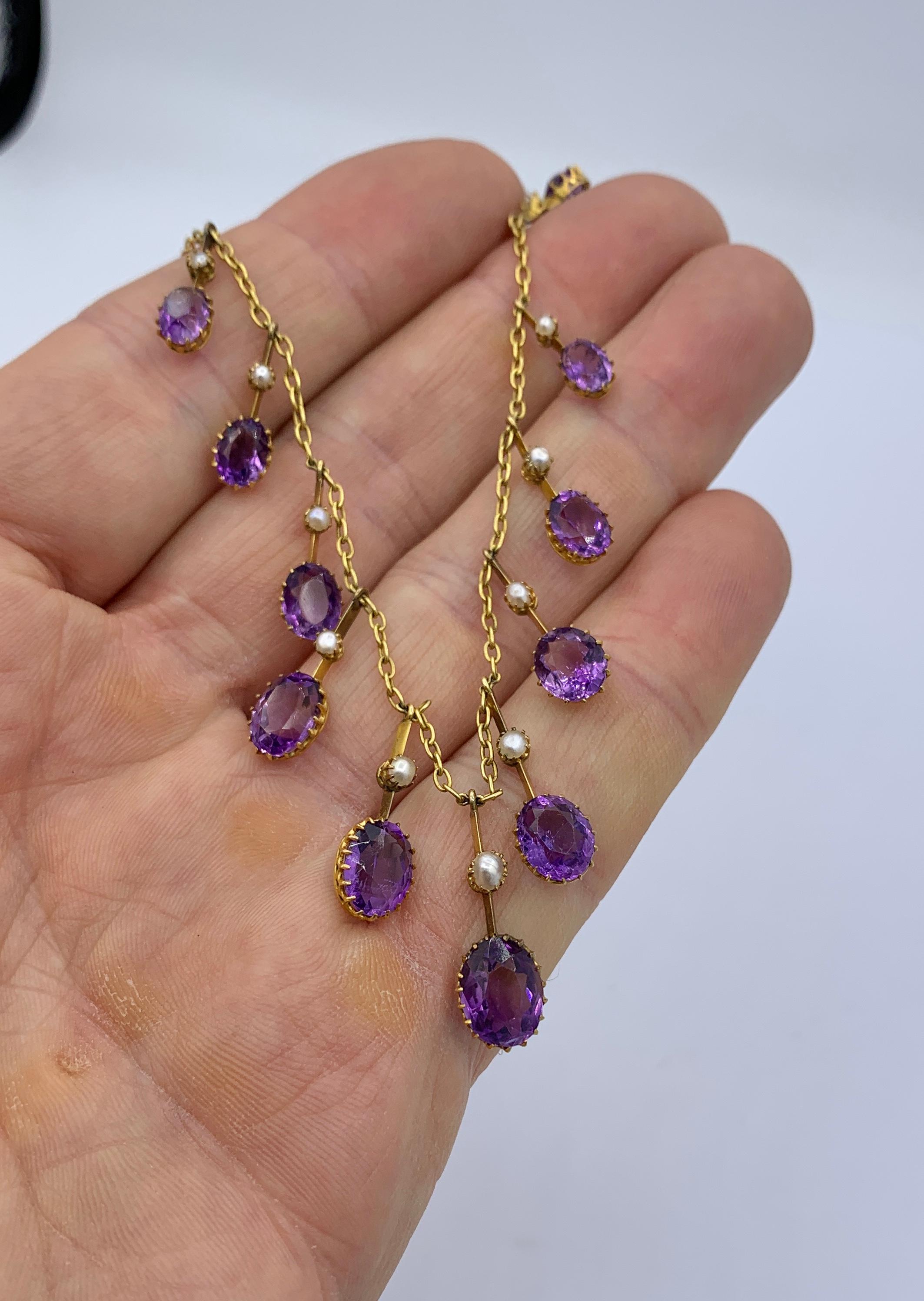 THIS IS A STUNNING ANTIQUE VICTORIAN - BELLE EPOQUE NECKLACE WITH THE MOST GORGEOUS NATURAL GRADUATED OVAL FACETED SIBERIAN AMETHYST GEMS SET IN A WONDERFUL PENDANT FRINGE DESIGN WITH KNIFE EDGE DROPS SET WITH PEARLS IN 9 KARAT GOLD.
This antique