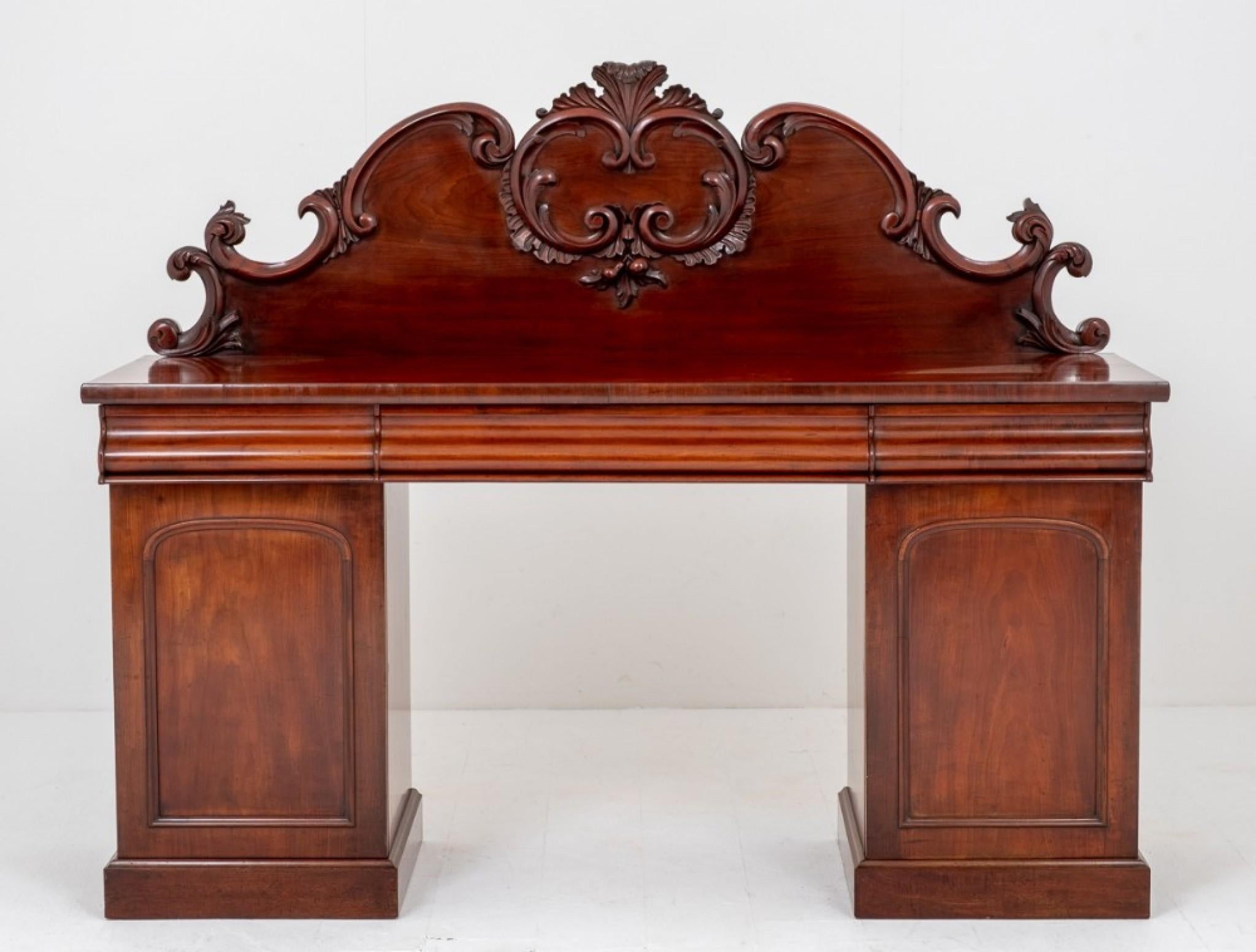 Victorian Mahogany Pedestal Sideboard.
Standing on a Plinth base with 2 cupboards.
Circa 1870
The left hand cupboard with sliding trays and the right hand cupboard with a lined cellaret.
The sideboard features 3 cushion shaped mahogany lined