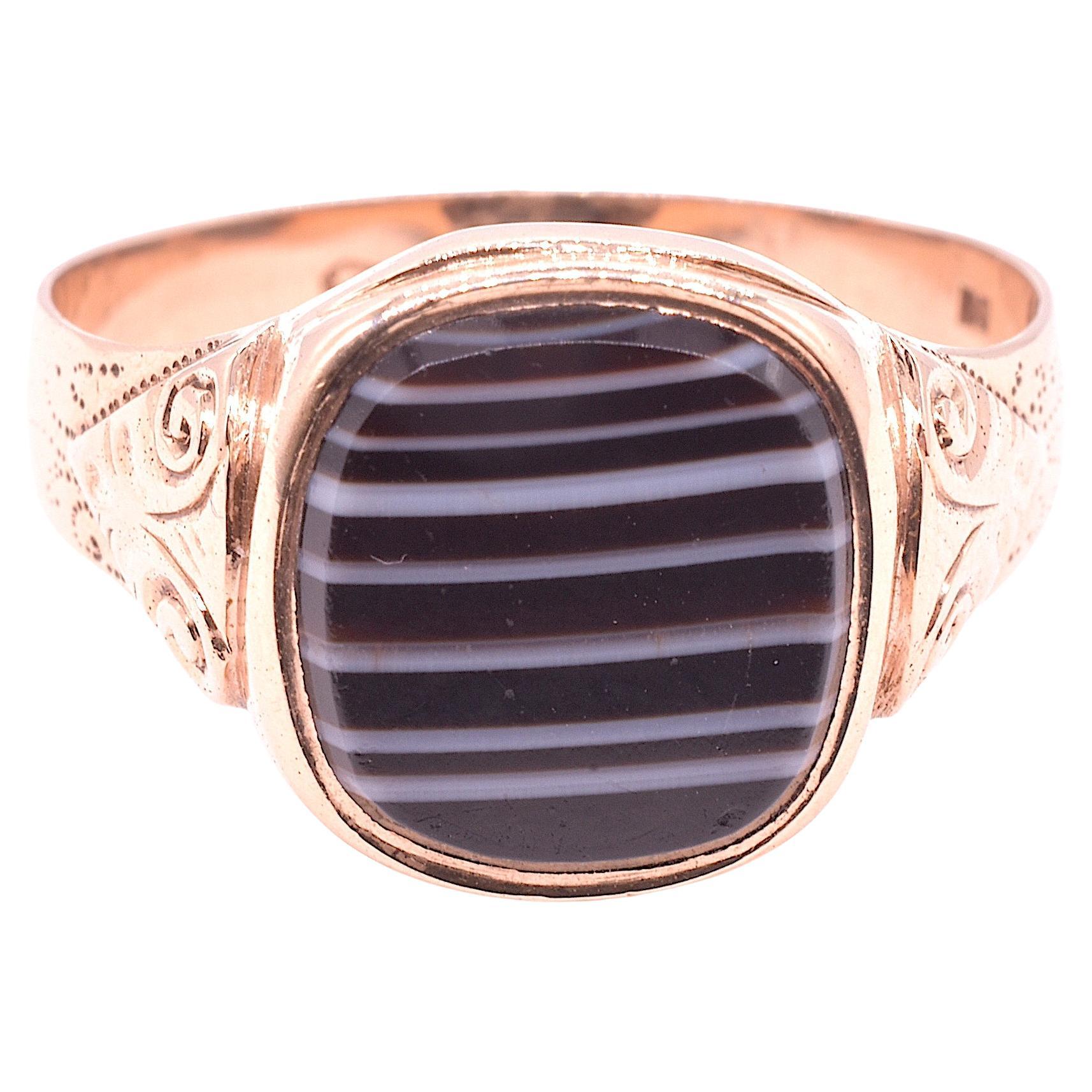 Unusual, rarely seen signet ring with a striking stone of banded agate. The ring has a very small cartouche stamp on the back, it could possibly be the harp indicated Irish origin. Banded agate is a form of quartz with parallel bands of black and