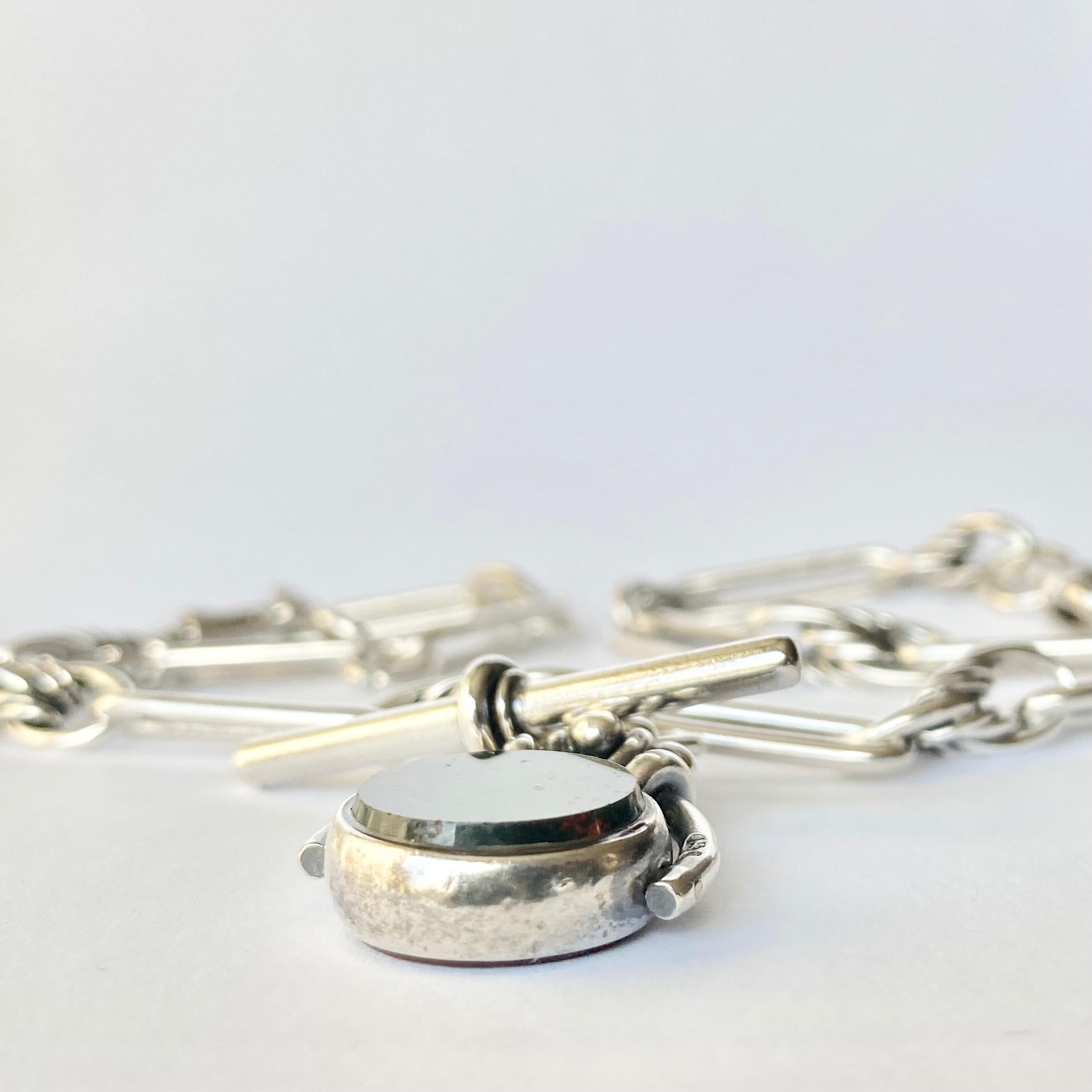 An Albert chain is an essential in any gents wardrobe or makes the perfect necklace. This particular Albert  is made up of trombone links with detailed links in-between. There are two dog clips and it holds a t-bar and fob with bloodstone and