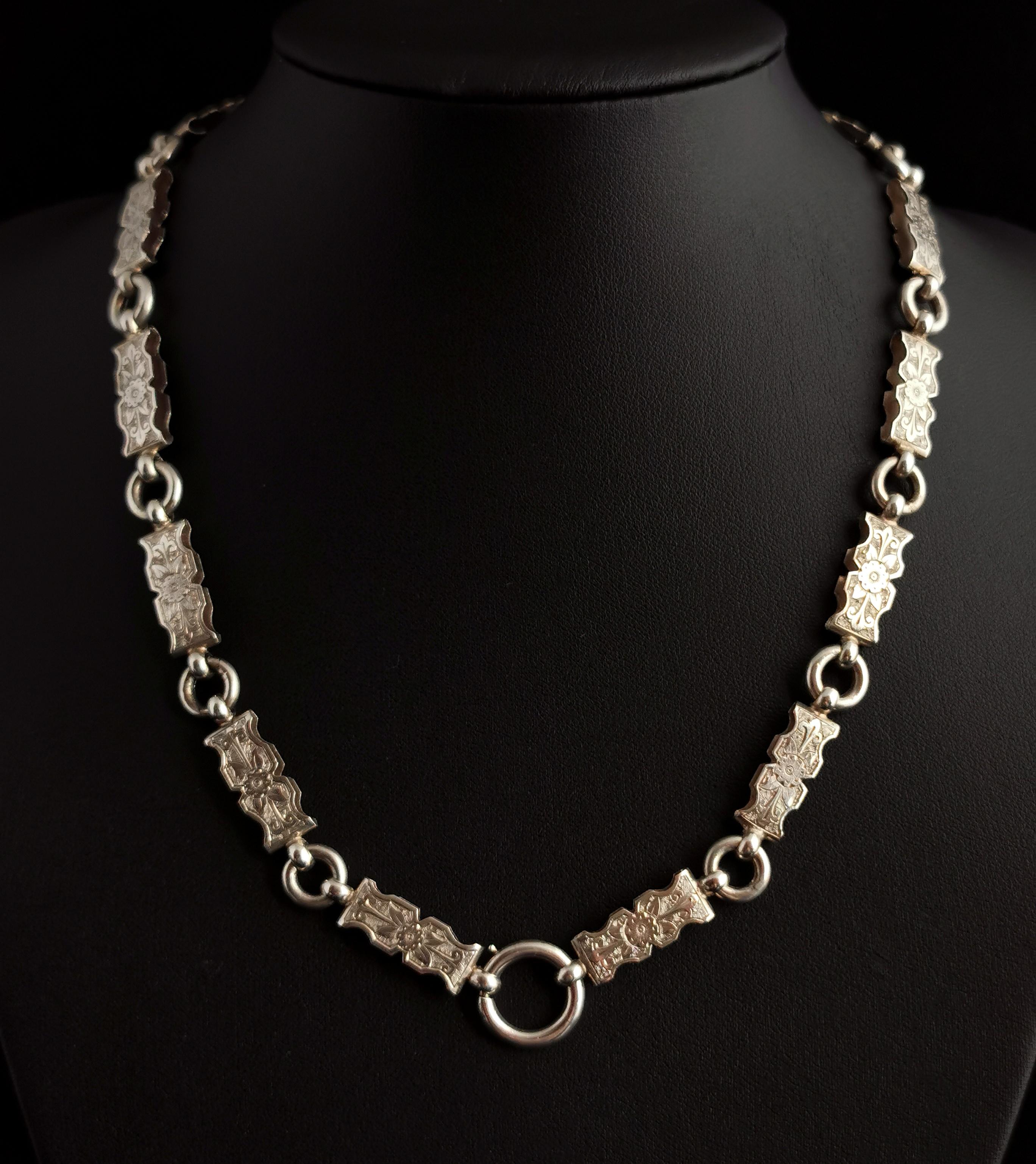 A gorgeous antique Victorian silver collar or book chain necklace.

There is so much detailing going on in this necklace with heavily engraved and scalloped links.

The links are medium width, and have beautiful aesthetic floral engraving to one