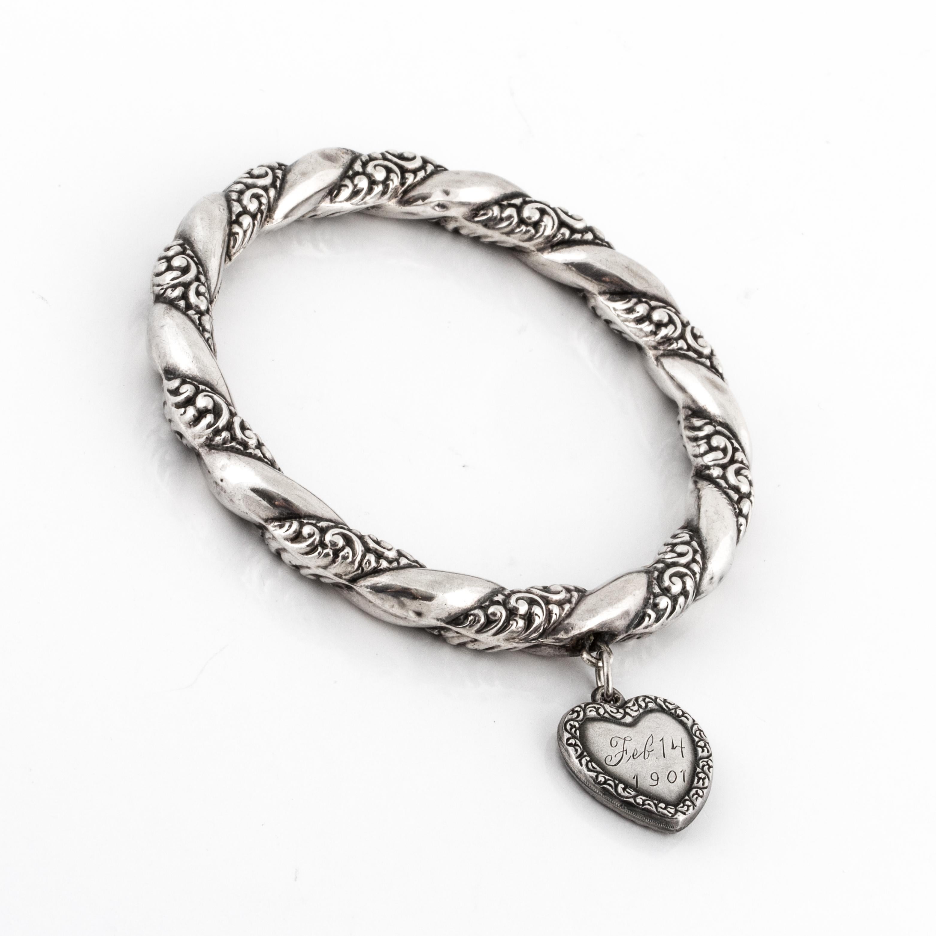 Edwardian sterling silver repoussé bangle bracelet with a heart charm.  The heart is inscribed 