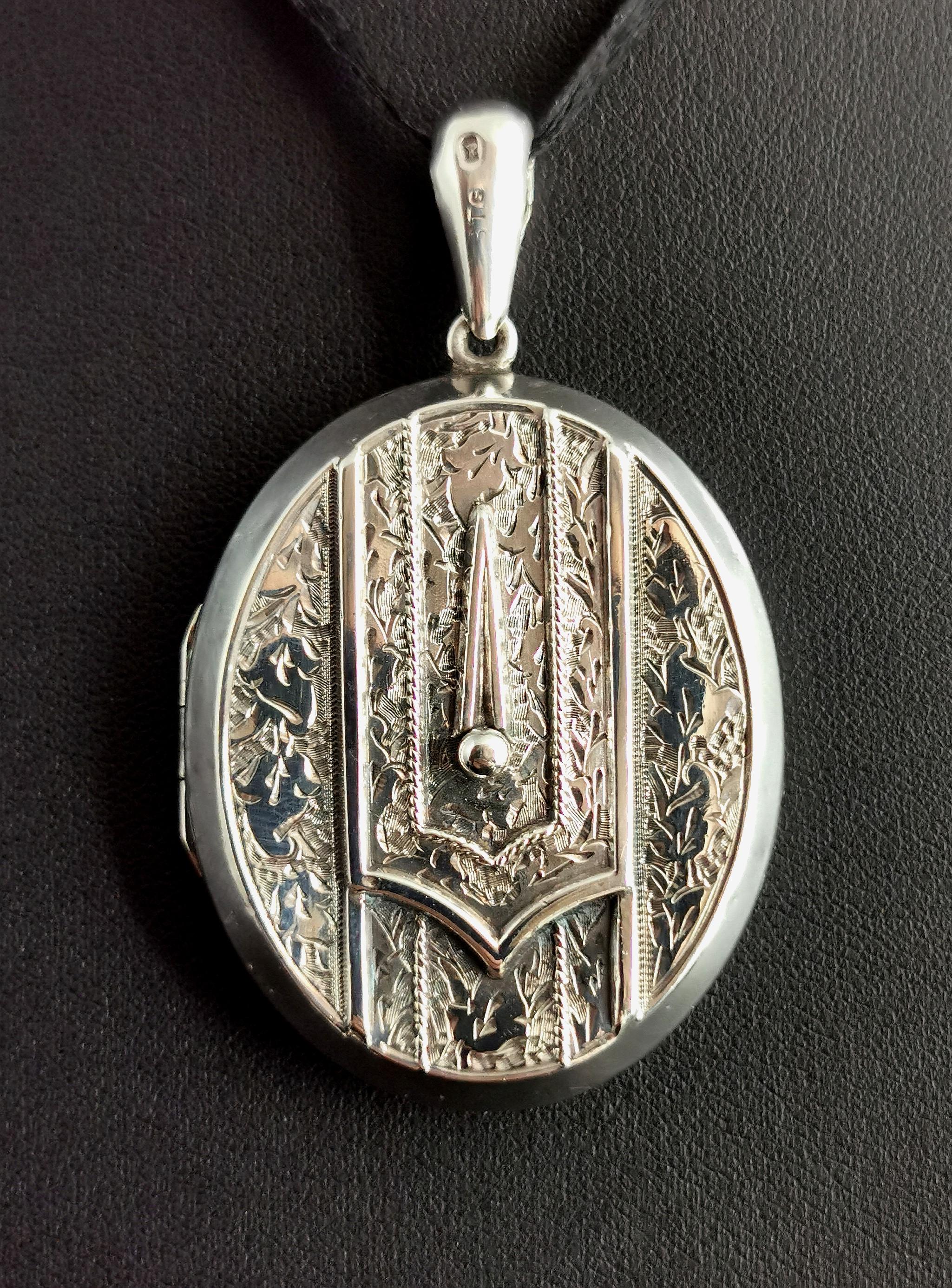 A stunning antique Victorian sterling silver locket pendant.

A large sized oval locket with a very fancy buckle design front with aesthetic style engraving.

It has a large integral bale, perfect for adding to a long antique chain or a choker style
