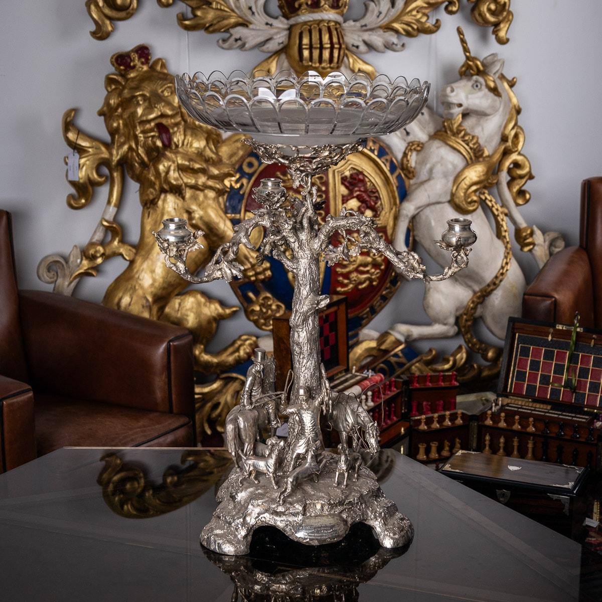 Antique 19th century Victorian impressively large and magnificent cast candelabra centrepiece, standing on shaped base, depicting a fox hunting scene featuring huntsmen, horses and hounds, the naturalistically modelled tree stem supporting three