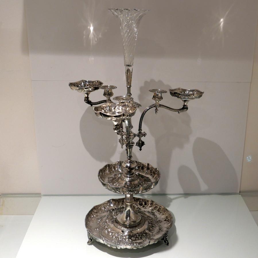 A truly impressive and incredibly large sterling silver Victorian centrepiece embellished with elegant fruits and matted floral motifs for decorative contrast. The centrepiece has a ‘full house’ of sections (very rare) fruit dishes, candle, comport