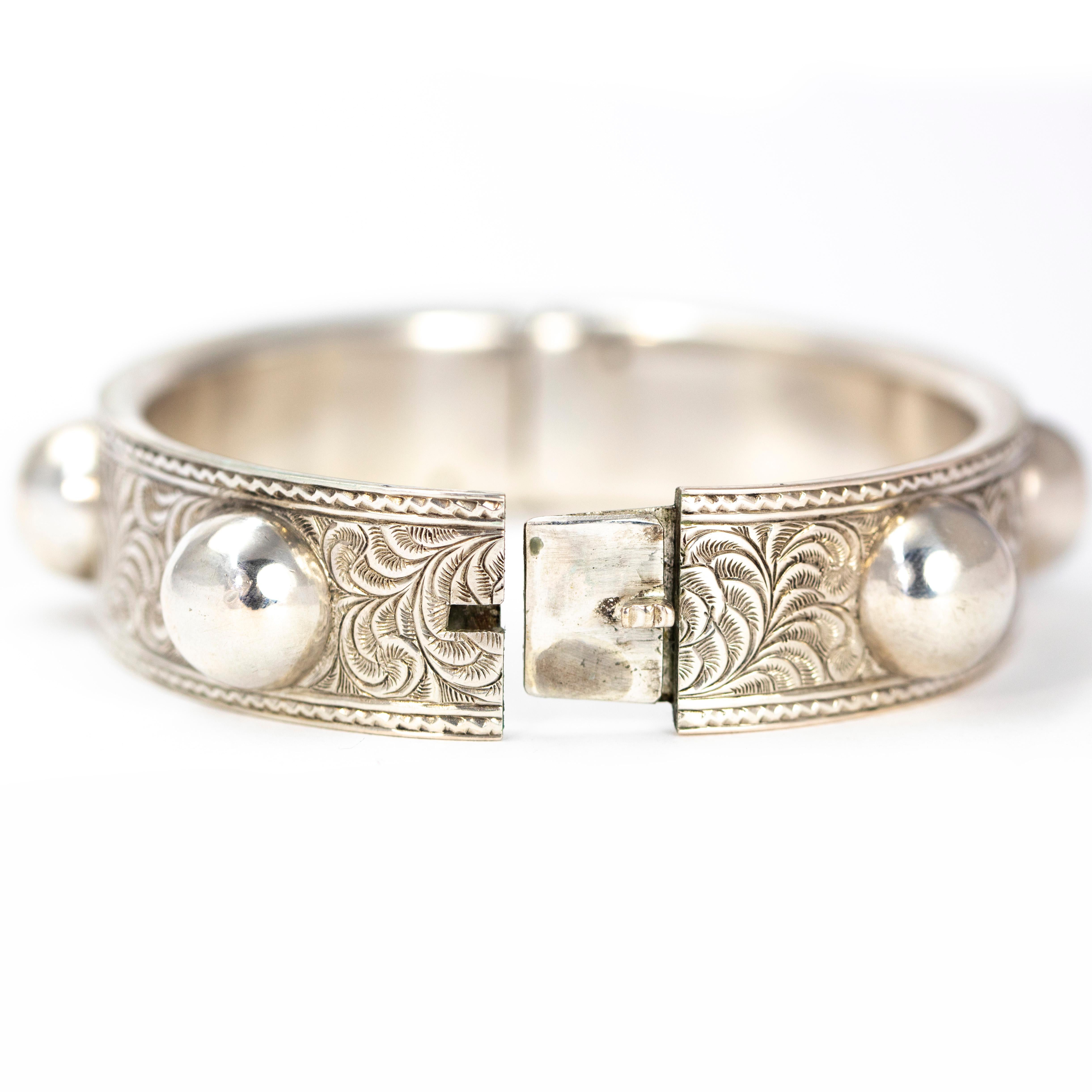 This gorgeous stylish silver bangle has intricate swirl detailing all the way around and also features glossy round orb detail. 

Inner Diameter: 56mm
Band Width: 15.5mm 

Weight: 33g