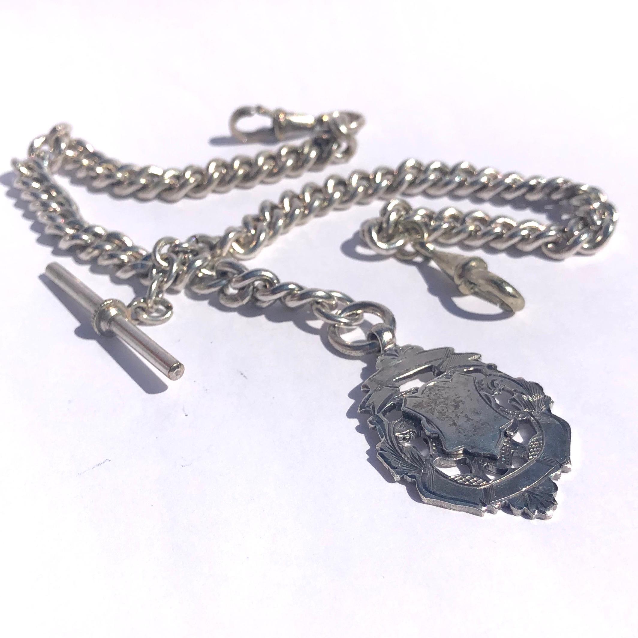 An Albert chain is an essential in any gents wardrobe. This particular Albert  is simple with two dog clips with a medallion and a t-bar in the middle. 

Length: 30.5cm 

Weight: 49.8g