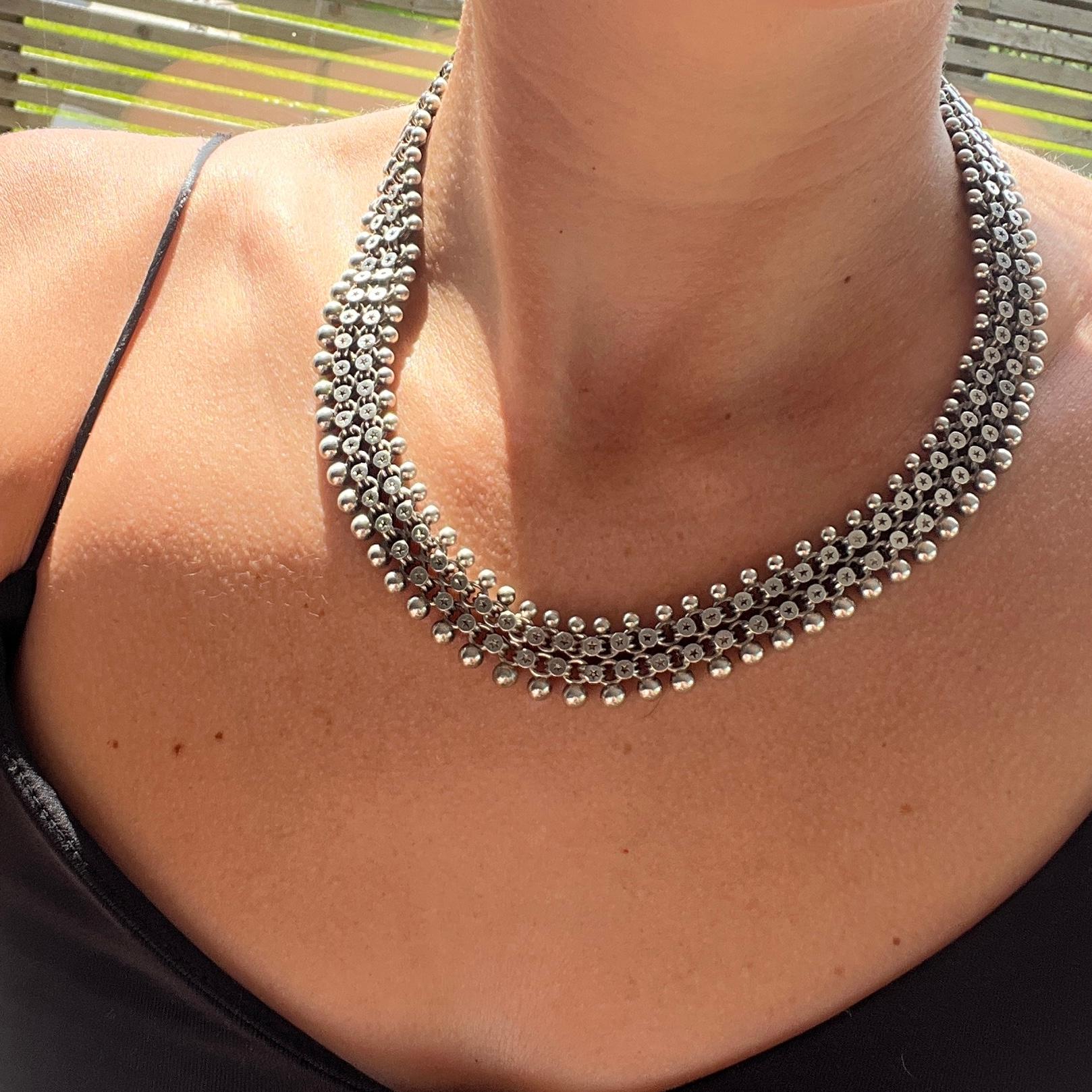 This necklace could be worn two ways, the more decorative side or the simple side. The links have wonderful stars on them on the one side and then the other side is smooth and glossy silver.  The necklace is fastened using a large bolt clasp.