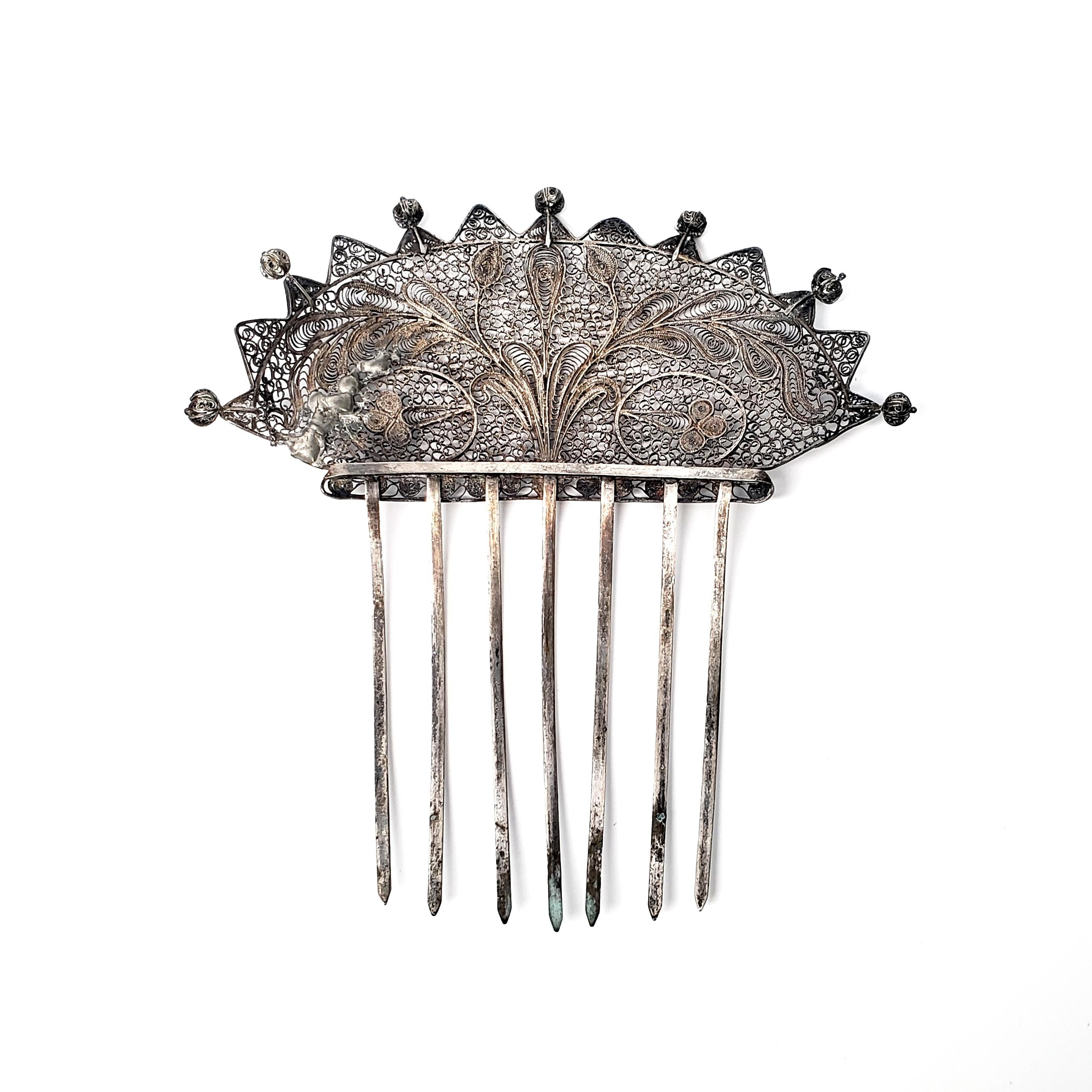 Large antique silver hair comb.

Beautiful filigree lace-like design with floral and leaf accents. Used for hairstyles typical of the late Victorian Era, circa 1890-1900. 