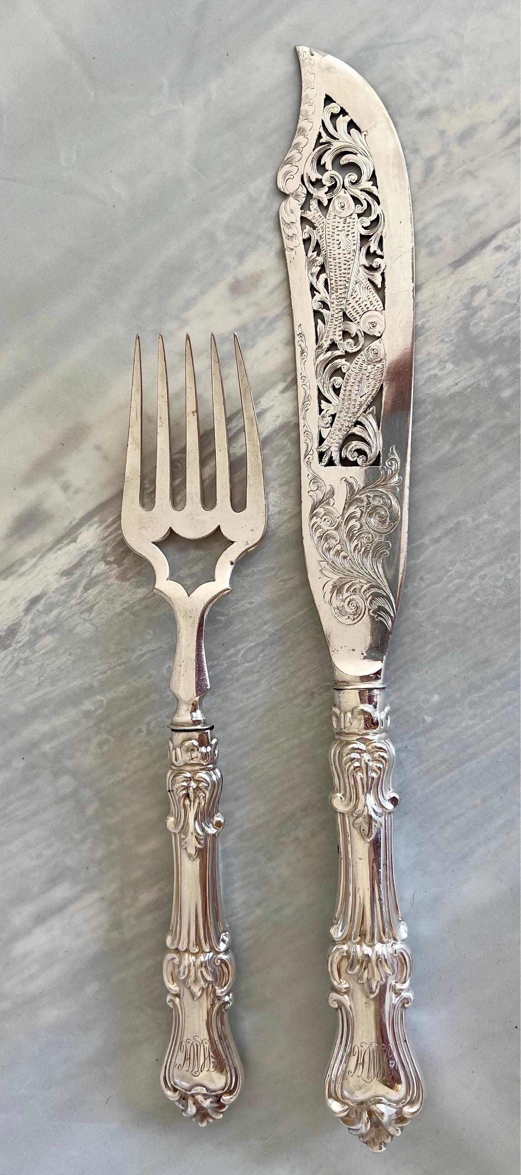 Cet élégant service à poisson en argent comprend un couteau et une fourchette, tous deux décorés de manière élaborée et conservés dans leur boîte de présentation originale doublée de velours. Je crois que les poignées sont en argent, mais je n'ai