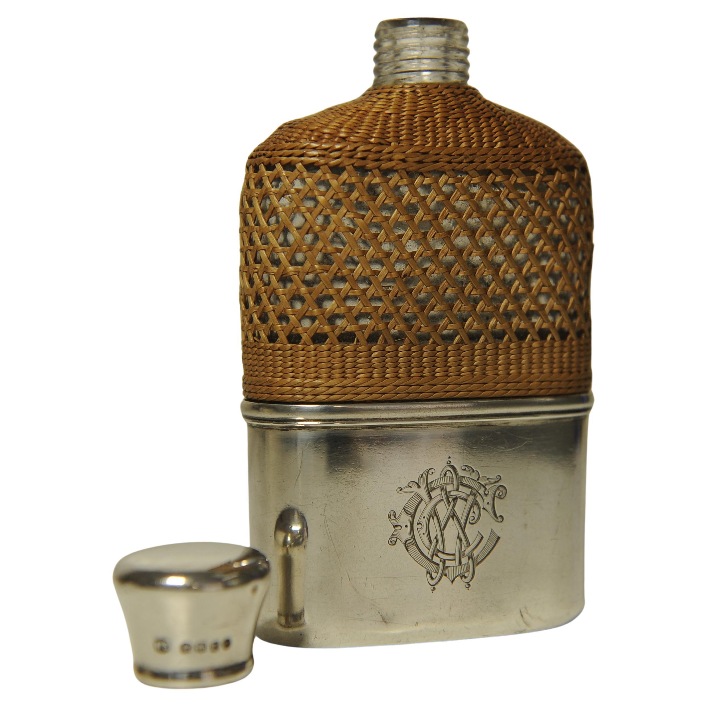 Elégante gourde victorienne en argent sterling et verre avec poignée en rotin tressé.

La flasque est munie d'une coupe amovible lavée à la dorure et d'un bouchon de liège en argent massif sur le couvercle. 

Par l'orfèvre du 19e siècle William
