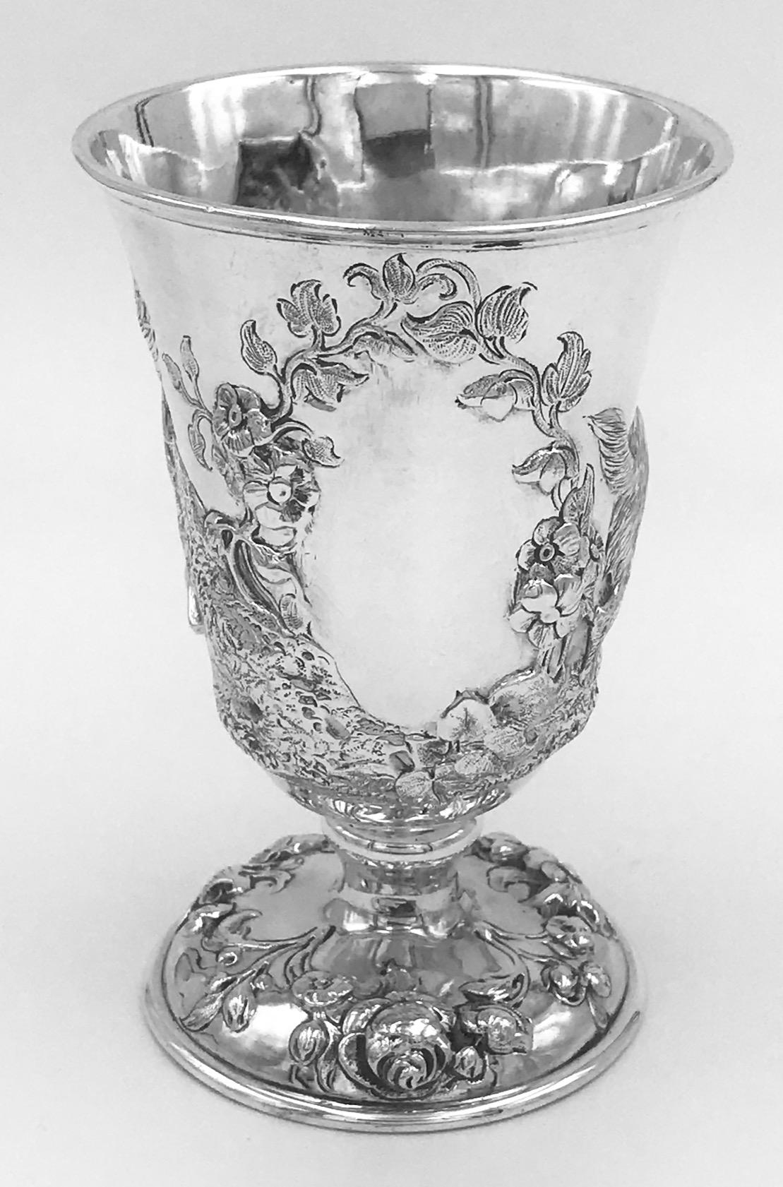 An antique Victorian silver goblet beautifully embossed with 3 dogs. It was made by Robert Hennell, and hallmarked in London in 1858.