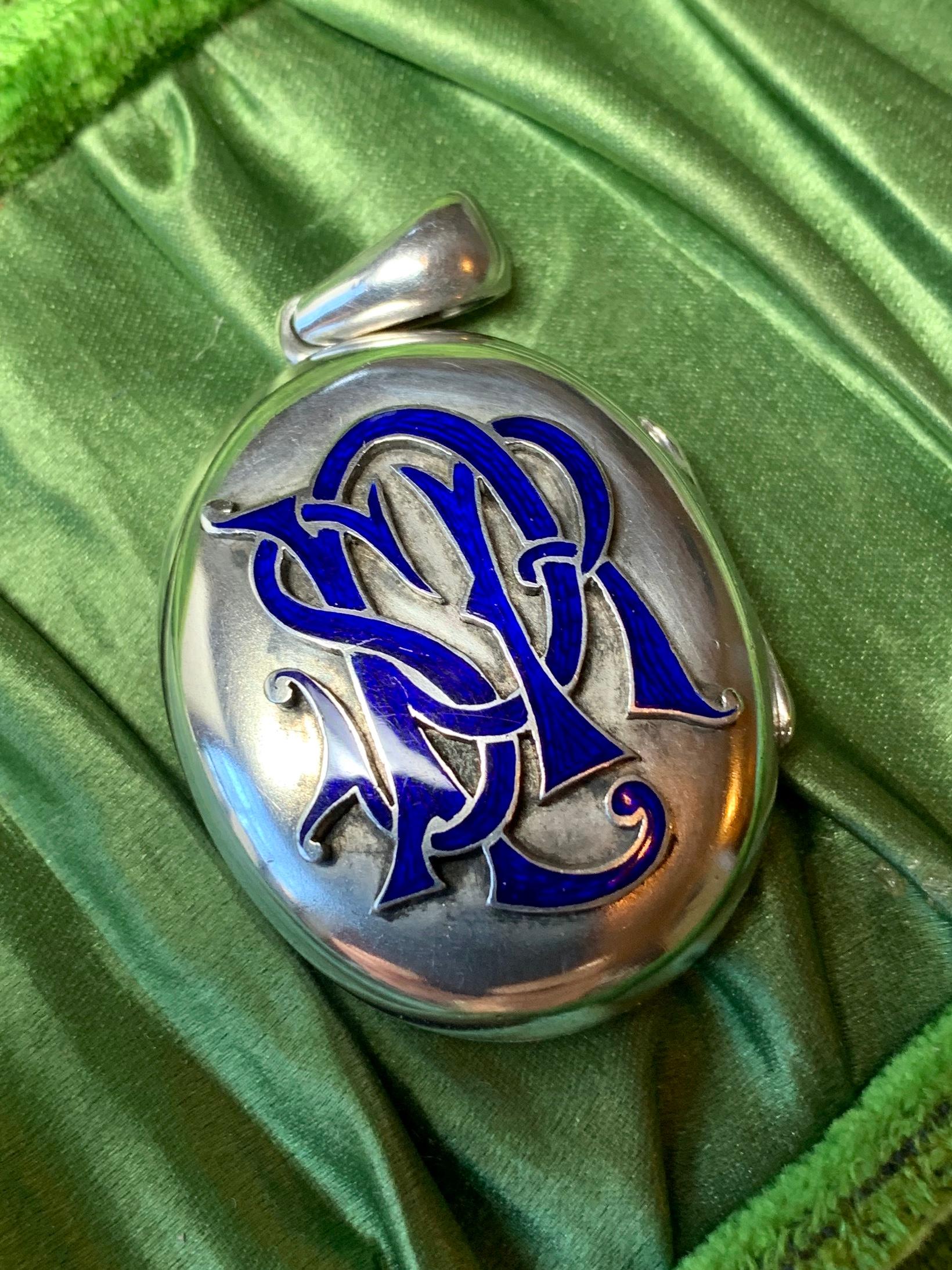 A wonderful Art Deco - Victorian Locket Pendant in Silver with a gorgeous royal blue enamel monogram.  The monogram in ornately raised letters of great beauty with fine royal blue enamel decoration.  Inside, the locket opens to reveal compartments