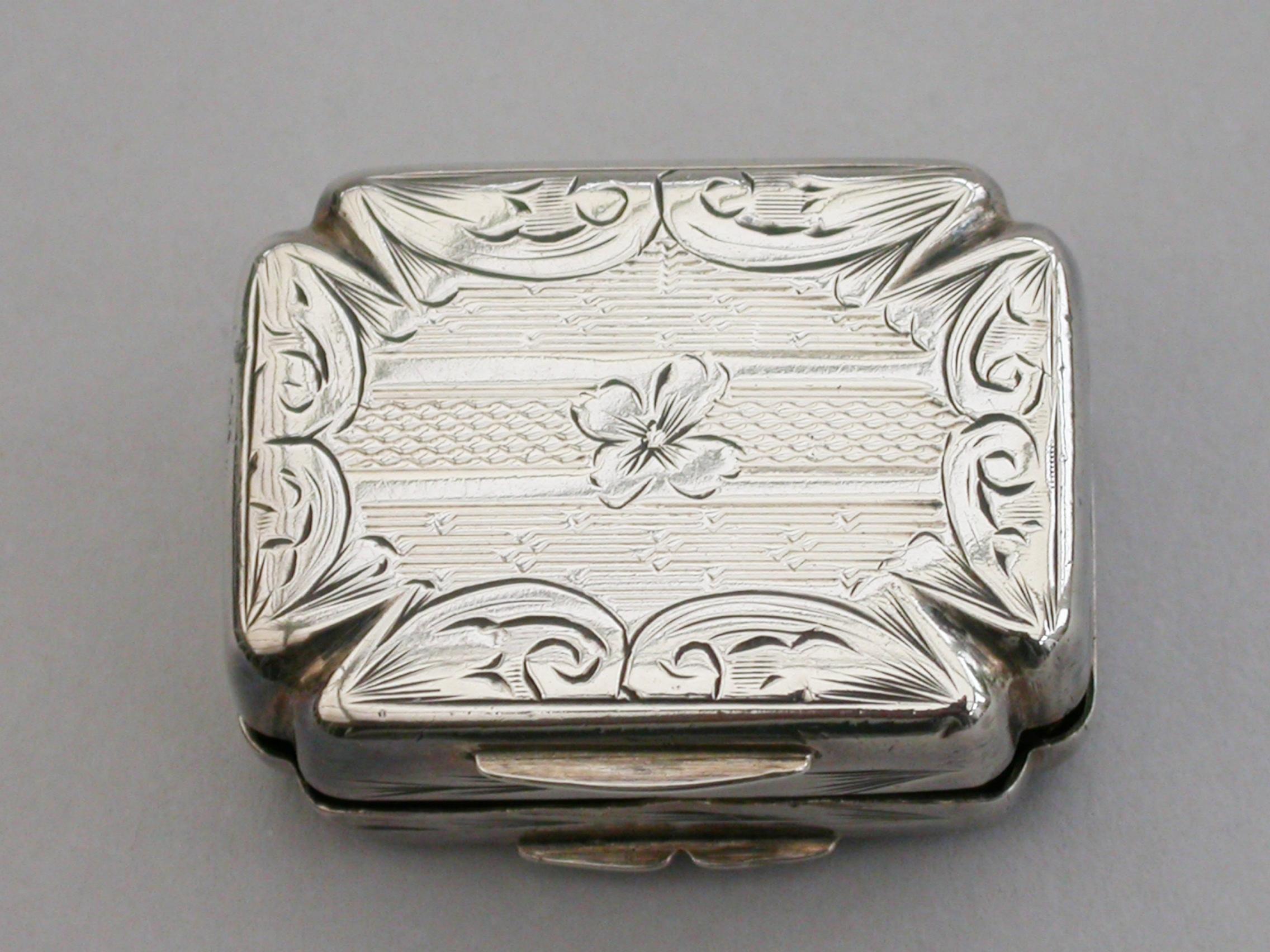 A rare Victorian silver Vinaigrette formed as a Maltese Cross, with all-over decoration of engraved scrolls and engine turning. The pierced silver gilt grille with flower heads and scrolls arising from a small cornucopia.

By Francis Clarke,