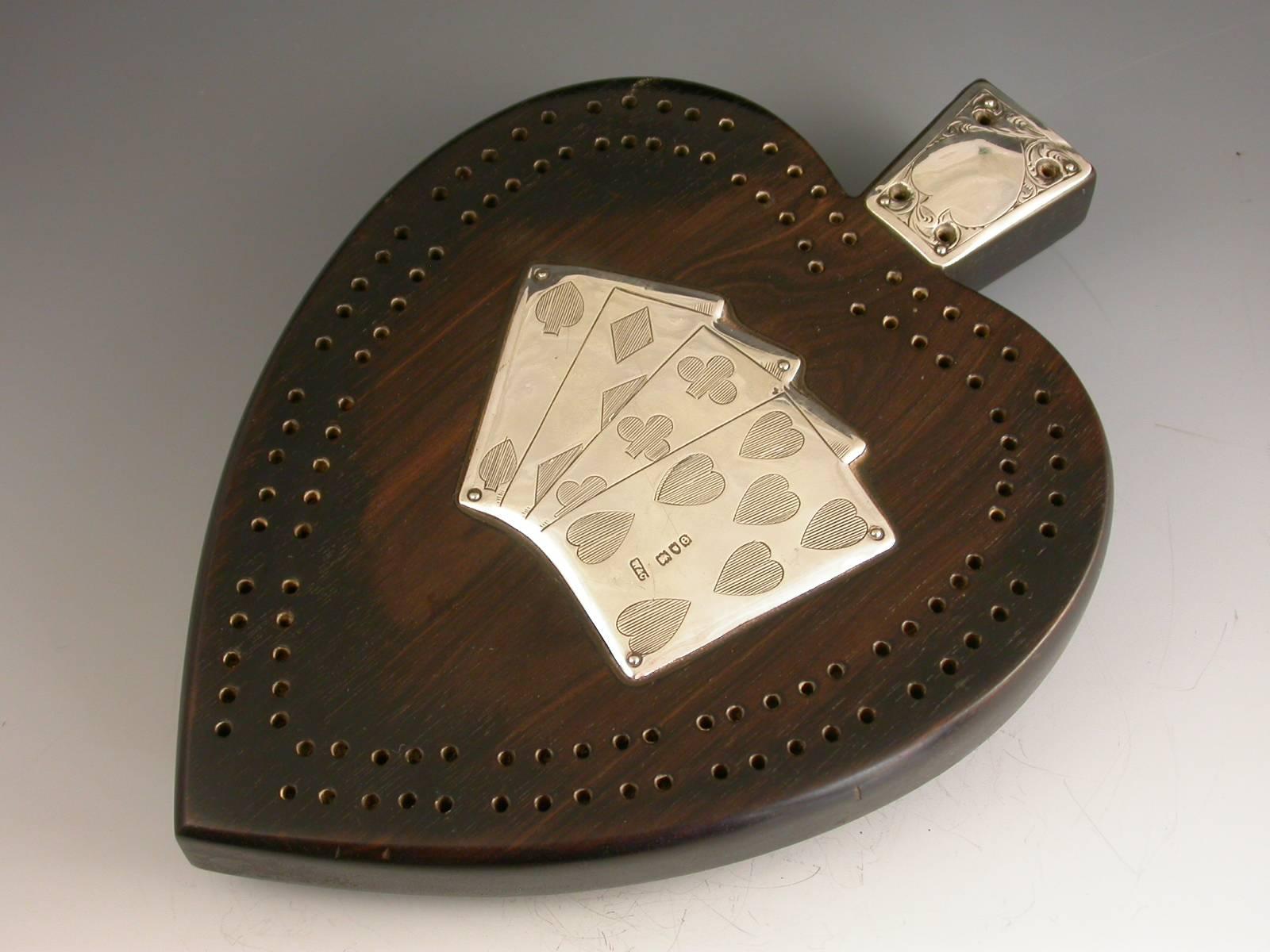 An unusual Victorian silver mounted ebony novelty Cribbage Board made in the shape of a spade suit, applied with four silver playing cards and a silver plate to the handle also engraved with a spade suit. Complete with four mother-of-pearl marker