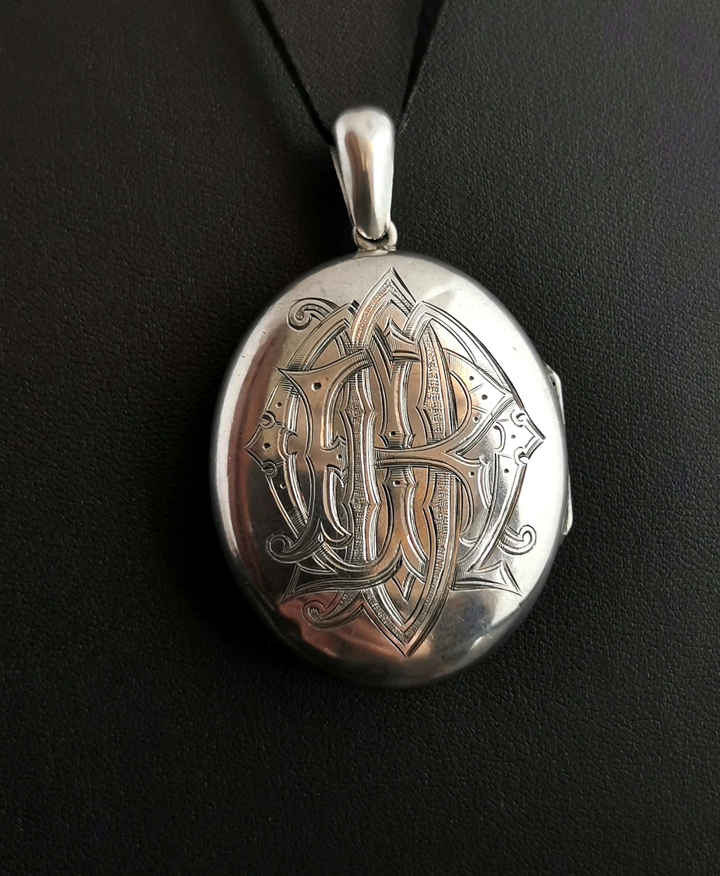 Ein atemberaubendes antikes viktorianisches Trauermedaillon aus Sterlingsilber. 

Ein großes ovales Medaillon mit einer glatten polierten Oberfläche und einer Vorderseite mit Monogramm. 

Es ist in ausgefallener gotischer Schrift mit den Initialen
