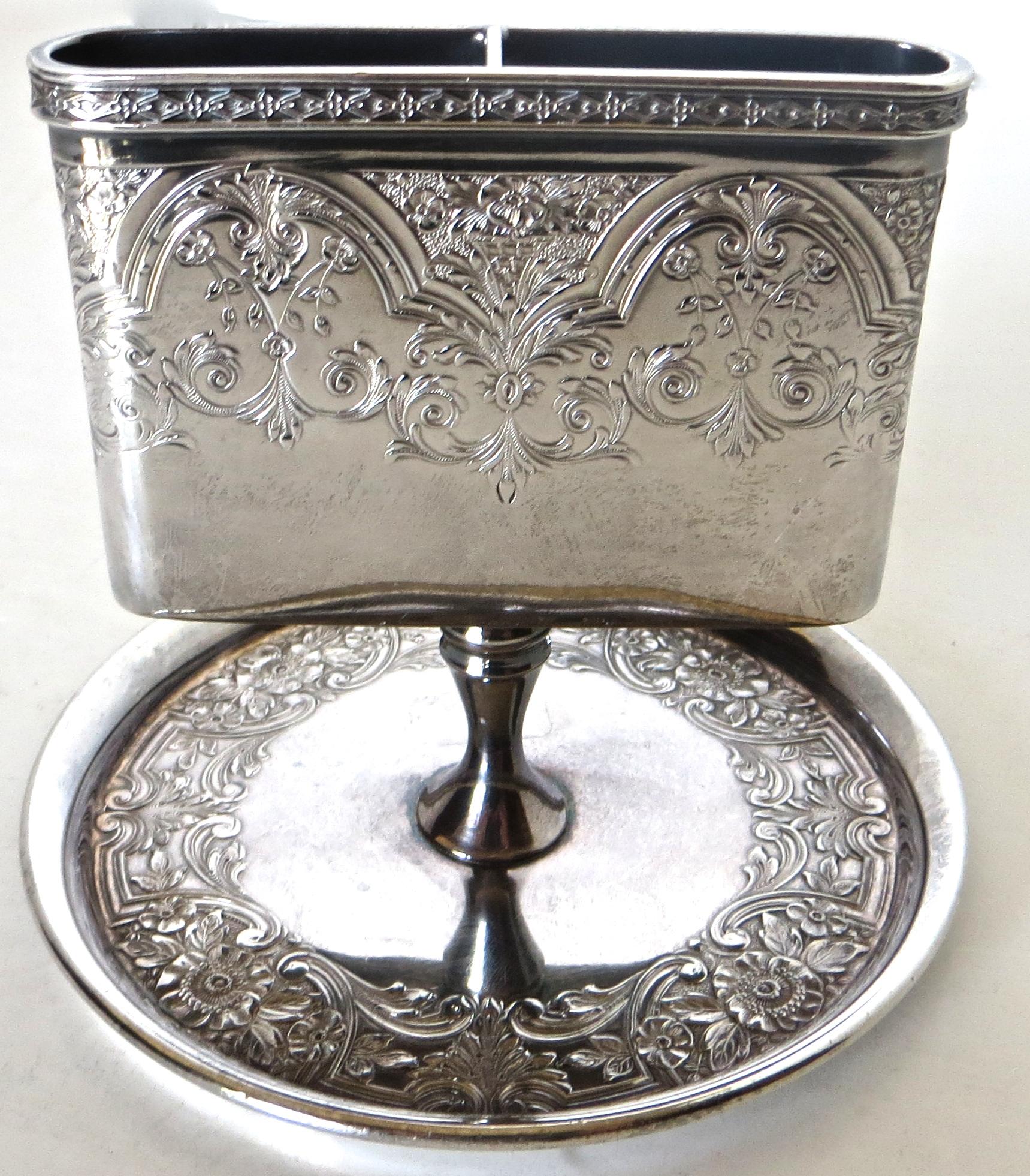 This Victorian match holder is highly decorated with etched floral design to both sides and wrapped completely around of the holder. An even more elaborate detailed etched floral pattern is applied to the waste receptacle circular dish below. The