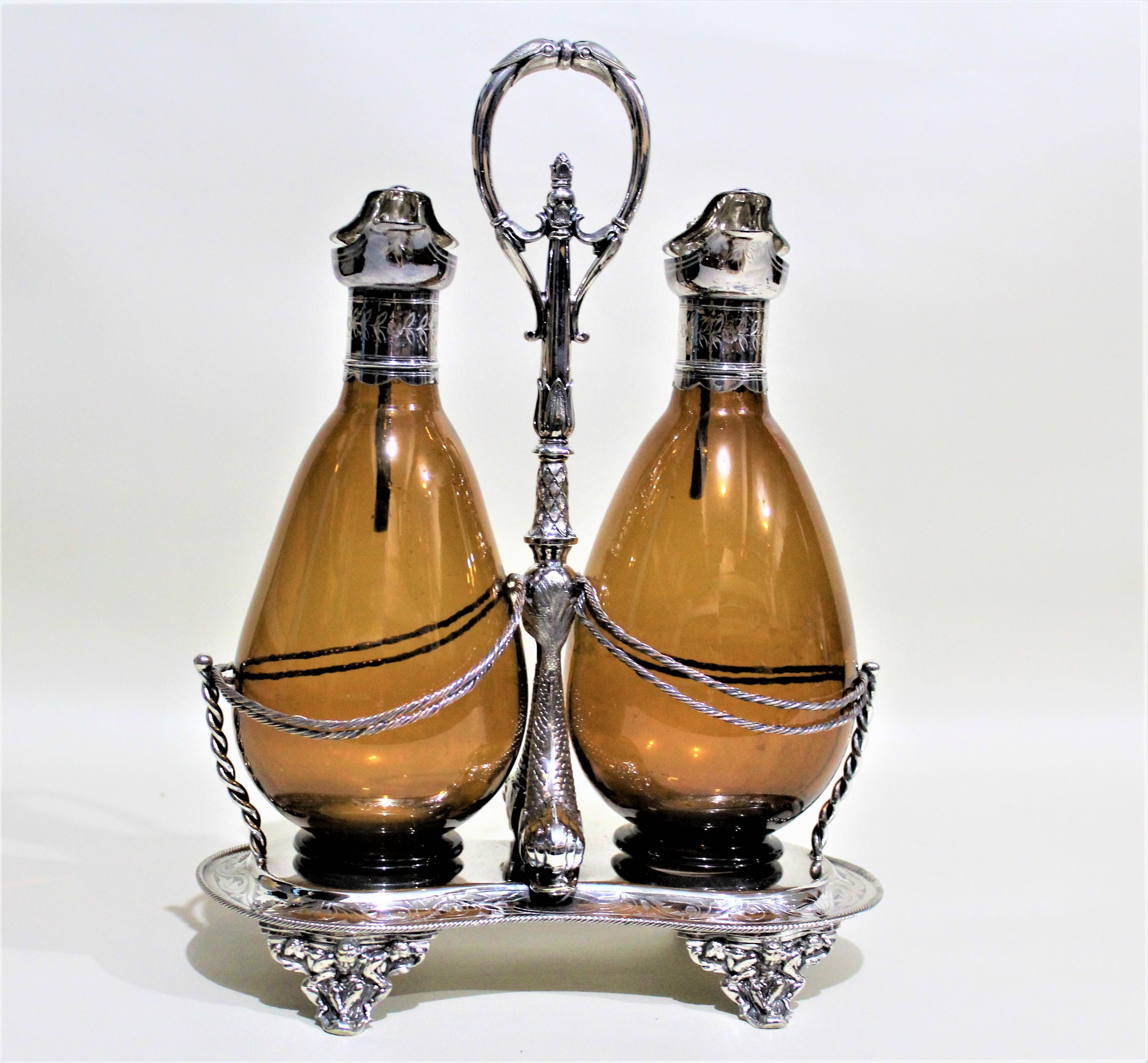 This silver plated Sherry stand, or tantalus, was most likely produced by an English maker in the Late 19th century. Although hallmarked, we have not been able to identify the specific maker. The stand is unique in that is has amber glass bottles