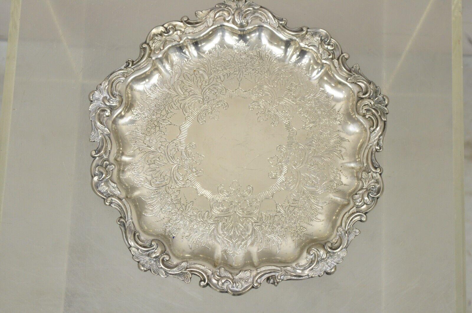 Victorian Silver Plated Small Scalloped Round Serving Platter Tray on Feet. Item features 3 Ball and Claw Paw Feet, Floral Etched Center, Nice Small Size. Circa Mid 20th Century. Measurements: 1