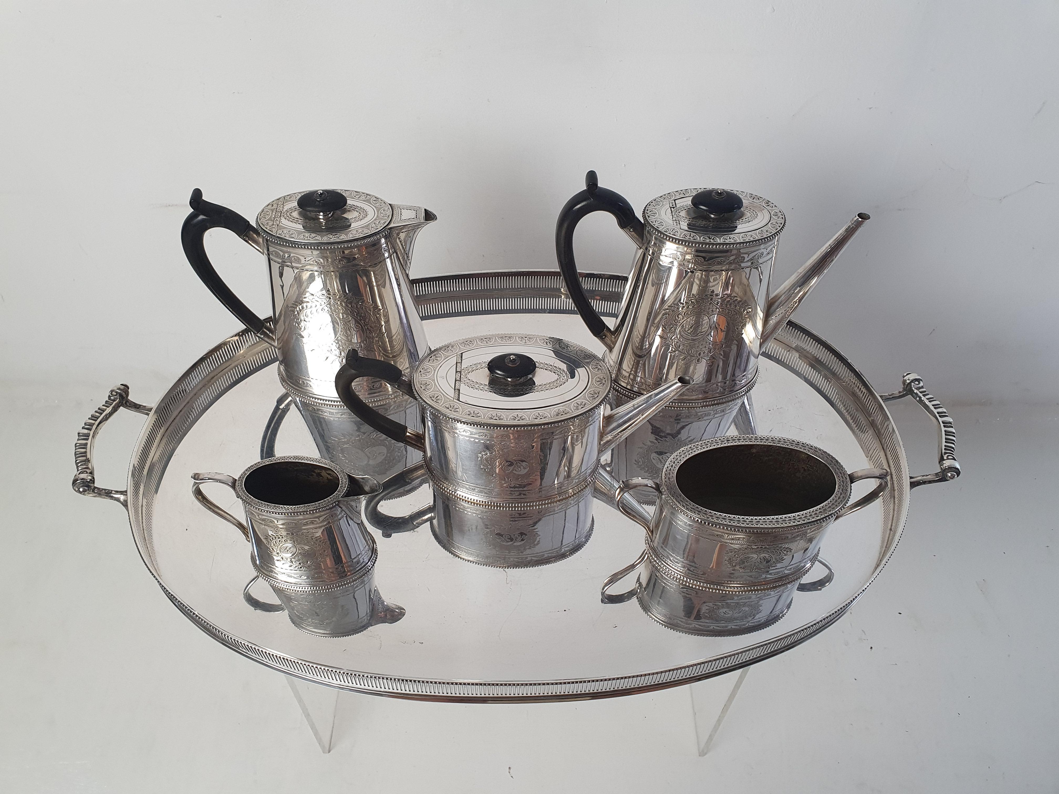 Classic high-quality silver-plated tea and coffee set. The pieces are embellished with elegant and elaborate engravings that frame the initials 