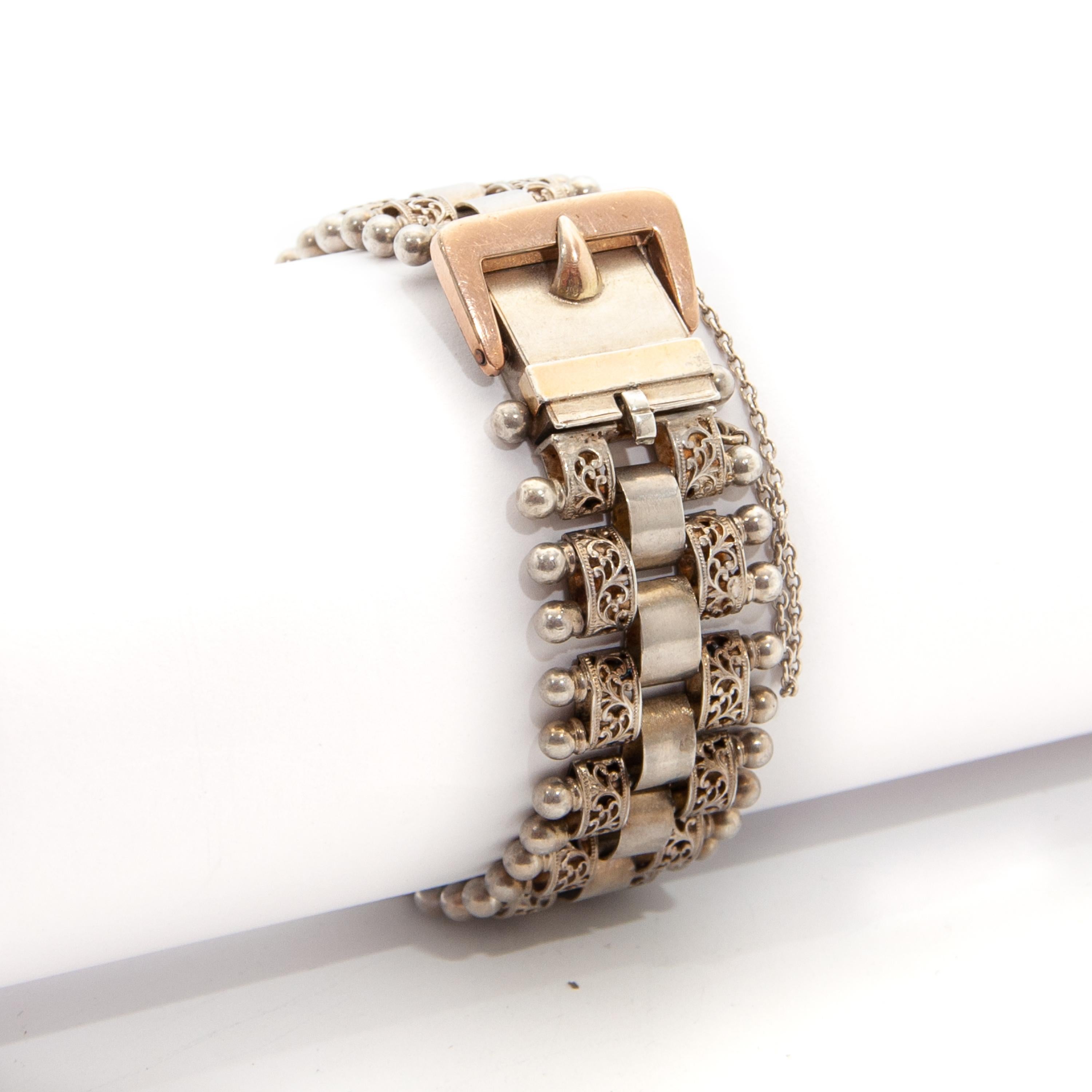 Un magnifique bracelet victorien antique à boucle, créé en argent et en or rose doré. La bande flexible de ce bracelet présente un design ajouré avec des maillons filigranes et des boules sur l'extérieur. Les maillons intérieurs ont une patine