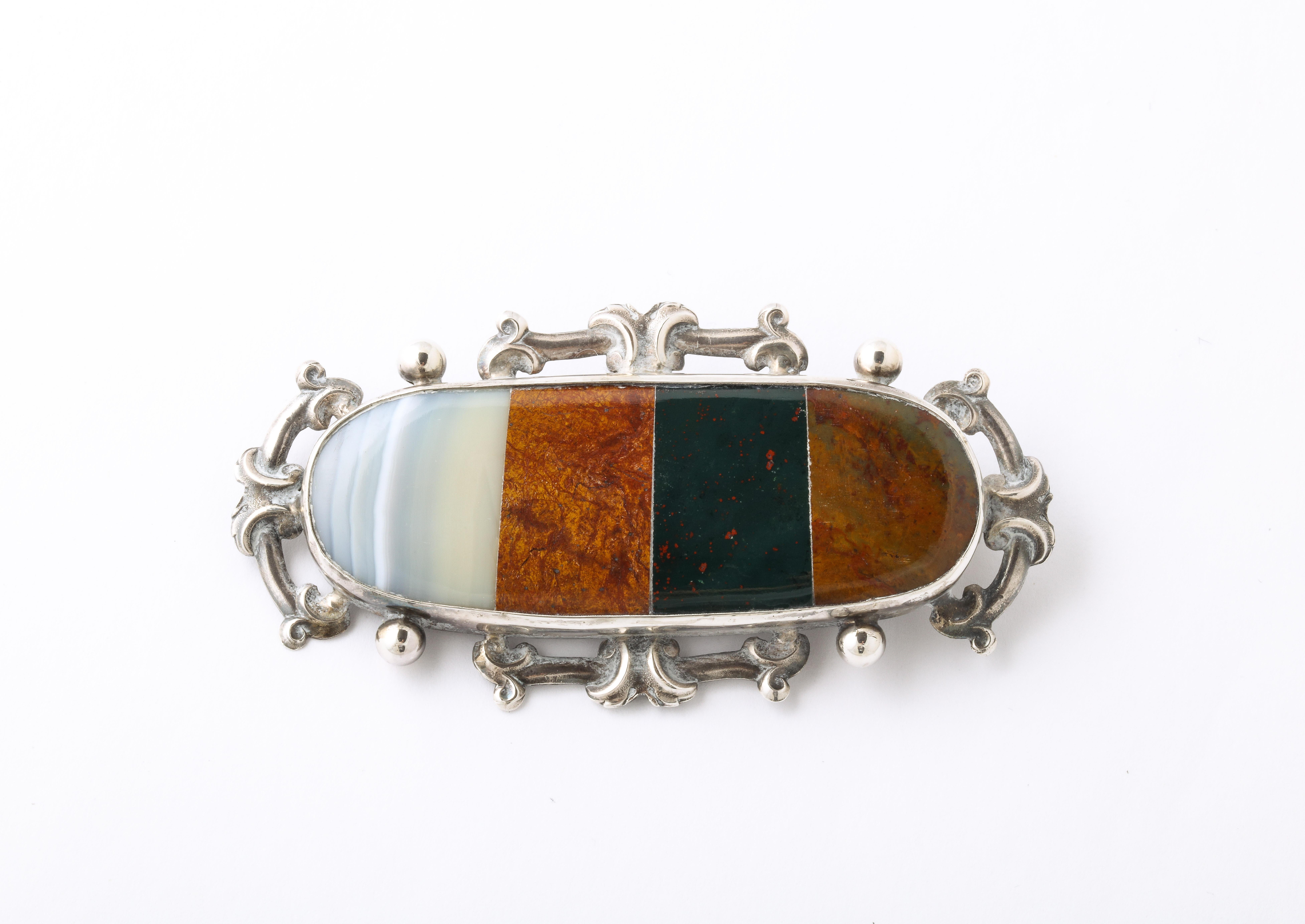 Set in Sterling, this substantial Scottish brooch is set with four colors of agate native to Scotland. Fine Scottish jewelry makers mastered the stone setting so that is was seamless. You can run your finger across the brooch and feel no divisions