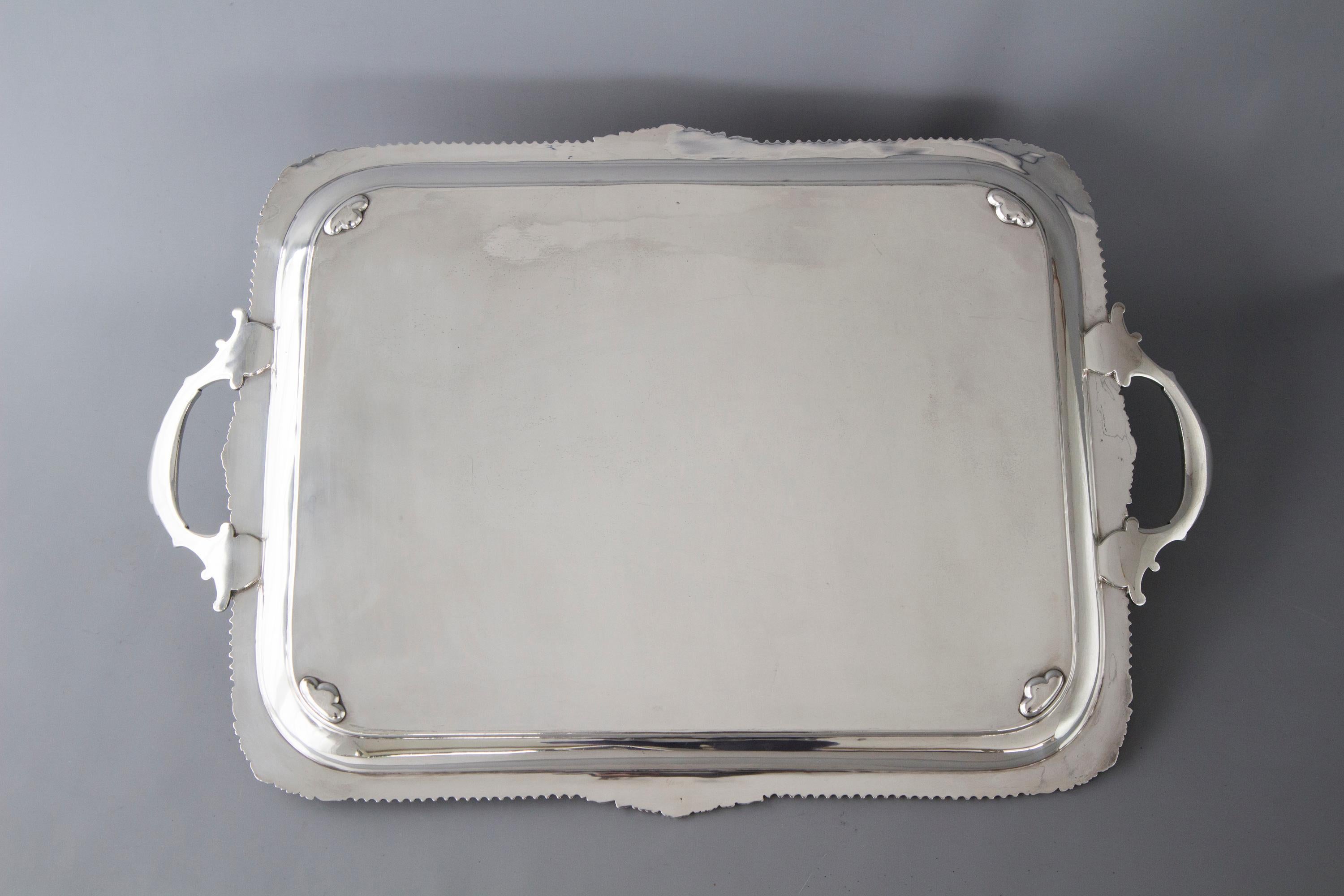 A very good quality silver tea or drinks tray of rectangular form. The border fluted with acanthus leaf decoration and shell form corners and twin shaped handles. The central plate in graved with an armorial depicting a stag lying down with a collar