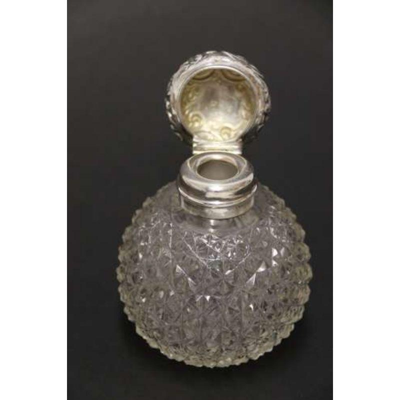 A Good Quality Victorian Silver and Cut Glass Perfume Bottle

This fine example is in very good condition. The bottle is made of fine crystal with bright cut hob nailed decoration. It has a hallmarked silver hinged lid with floral repousse