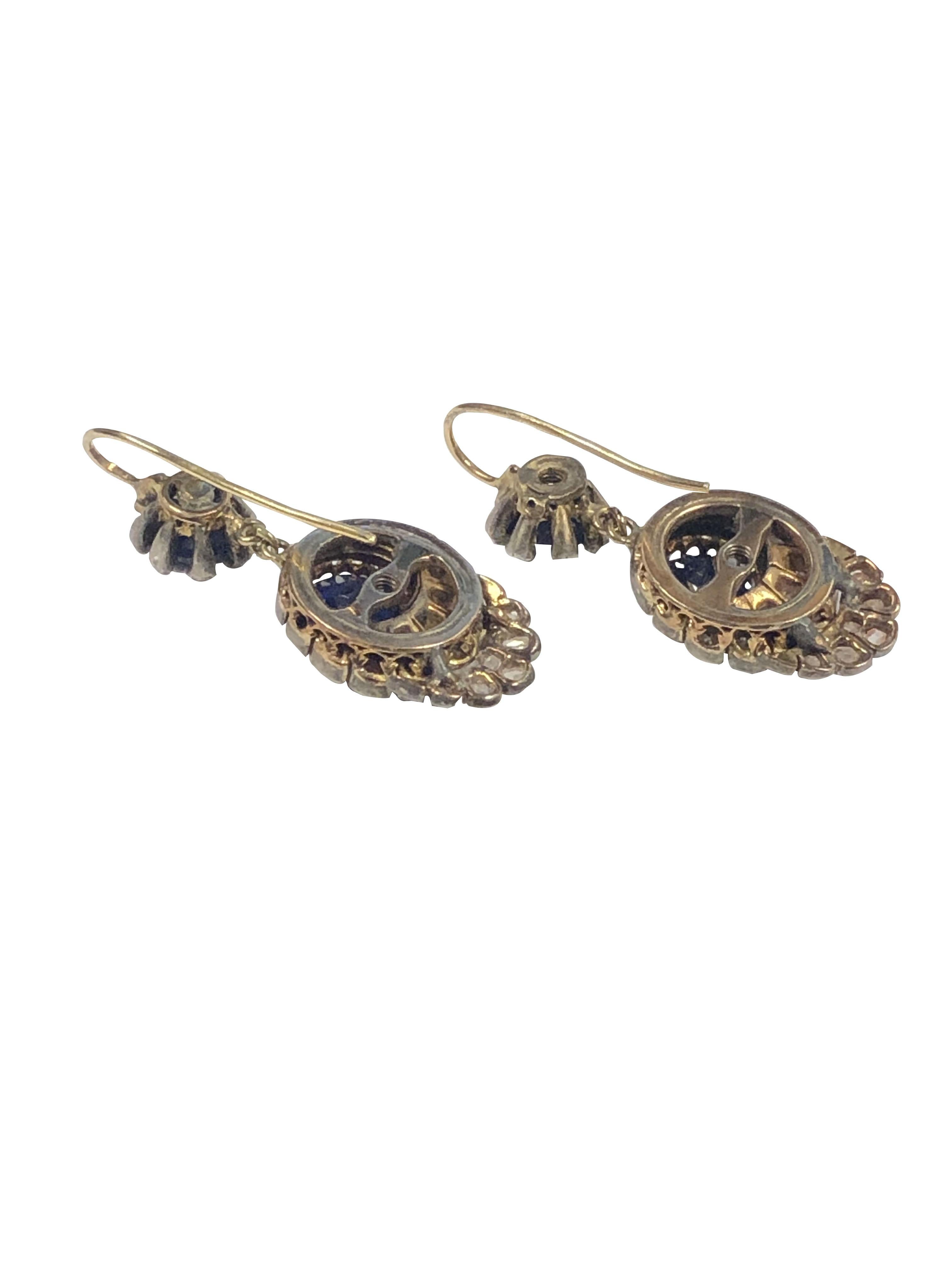 Circa 1890 Silver topped and 14k Gold Earrings, having a scalloped shell design, the Earrings measures 1 1/2 inches in length and 1/2 inch wide, set with Rose cut Diamonds and Sapphires with the central Sapphire being an old cut and measuring 7 M.M.