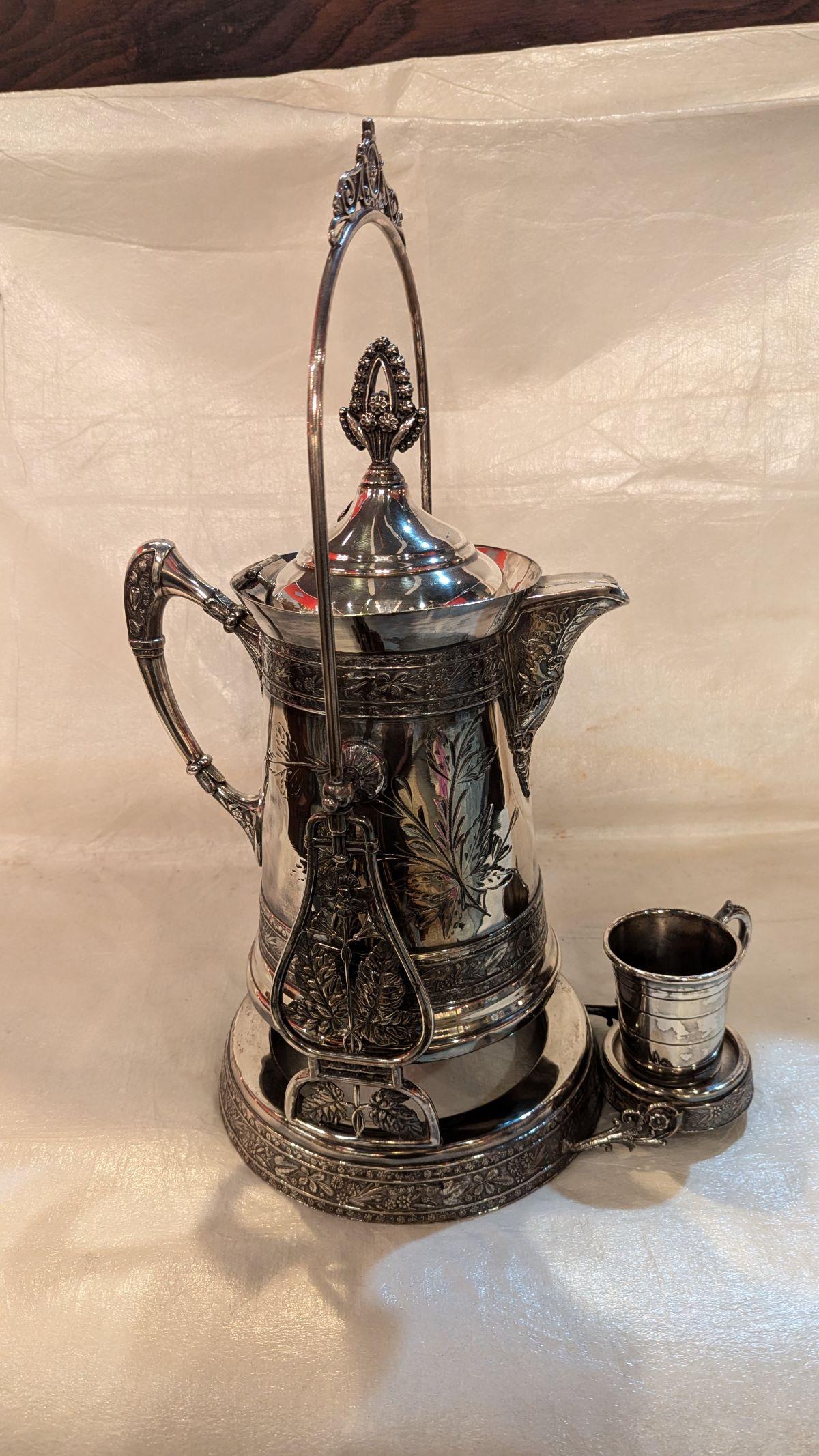 Victorian quadruple silverplate ice water tipper, for the owner of the manor.  Made to serve ice water by tipping the pitcher forward dispensing into your cup without having to actually pick the pitcher up.  Beautiful tracing and etching with grand