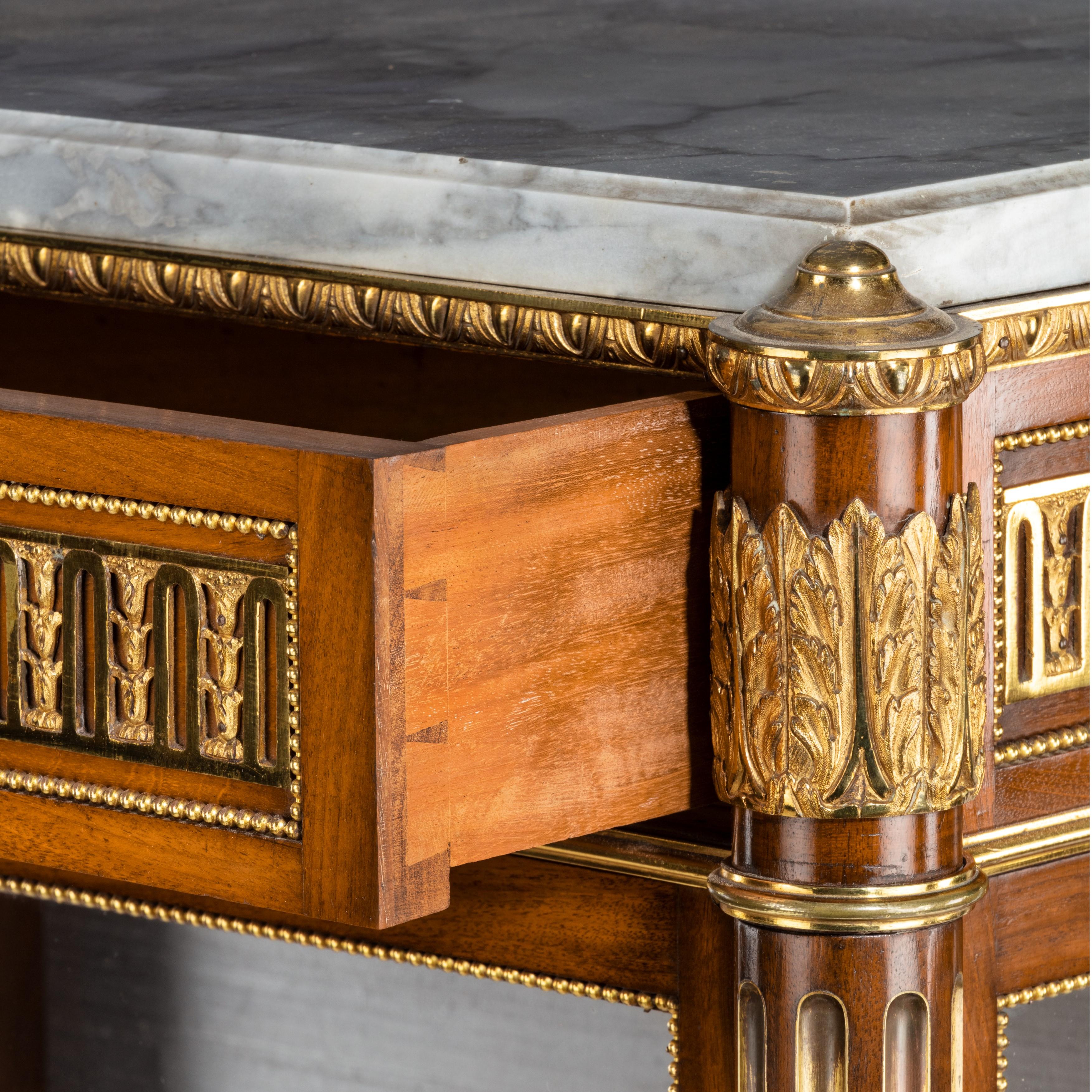 A Victorian single door mahogany cabinet in the French taste, of upright rectangular form with a grey marble top set above a frieze with a disguised drawer flanked by two columns styled as quivers with feathers above gilded fluting, ormolu mounts,