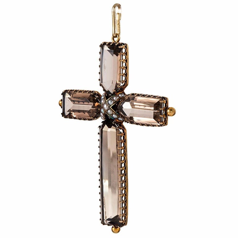 A substantial and beautiful late Victorian cross, set with minimally faceted sections of smoky quartz and accented with a pearl centerpiece, this piece will make a lovely addition to your antique jewelry wardrobe. Suspend it from an antique chain or