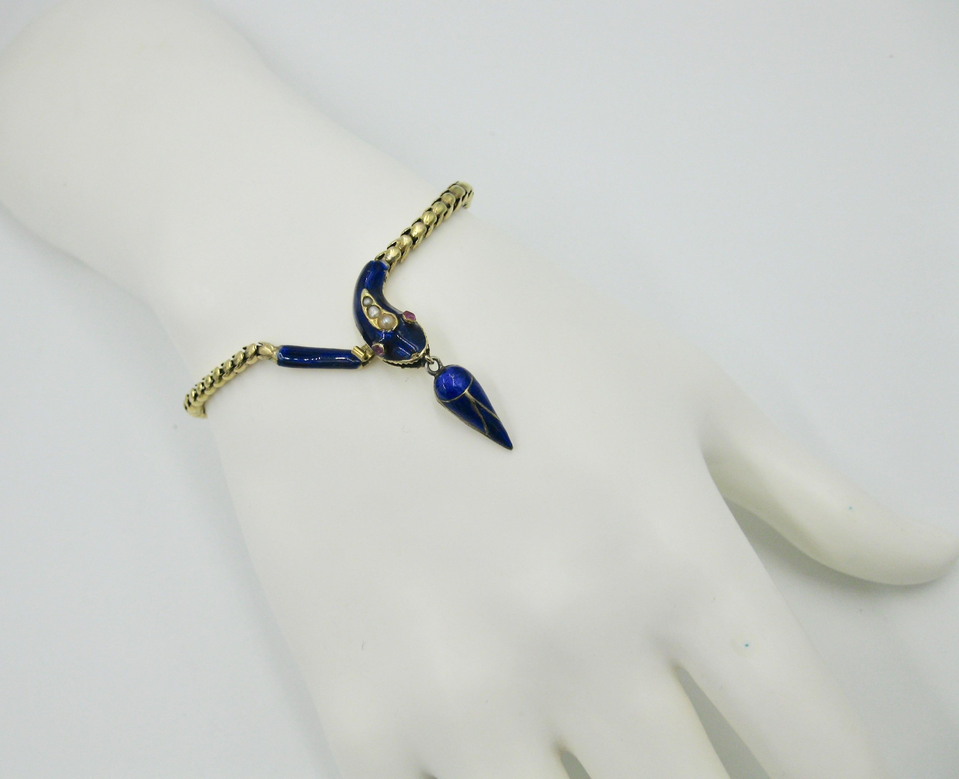 This is a rare and wonderful antique Victorian Snake Bracelet.  The snake bracelet dates to circa 1840.  The snake head is set with faceted round Rubies and Pearls.  The snake's head, tail and cone shaped pendant are adorned with vivid royal blue