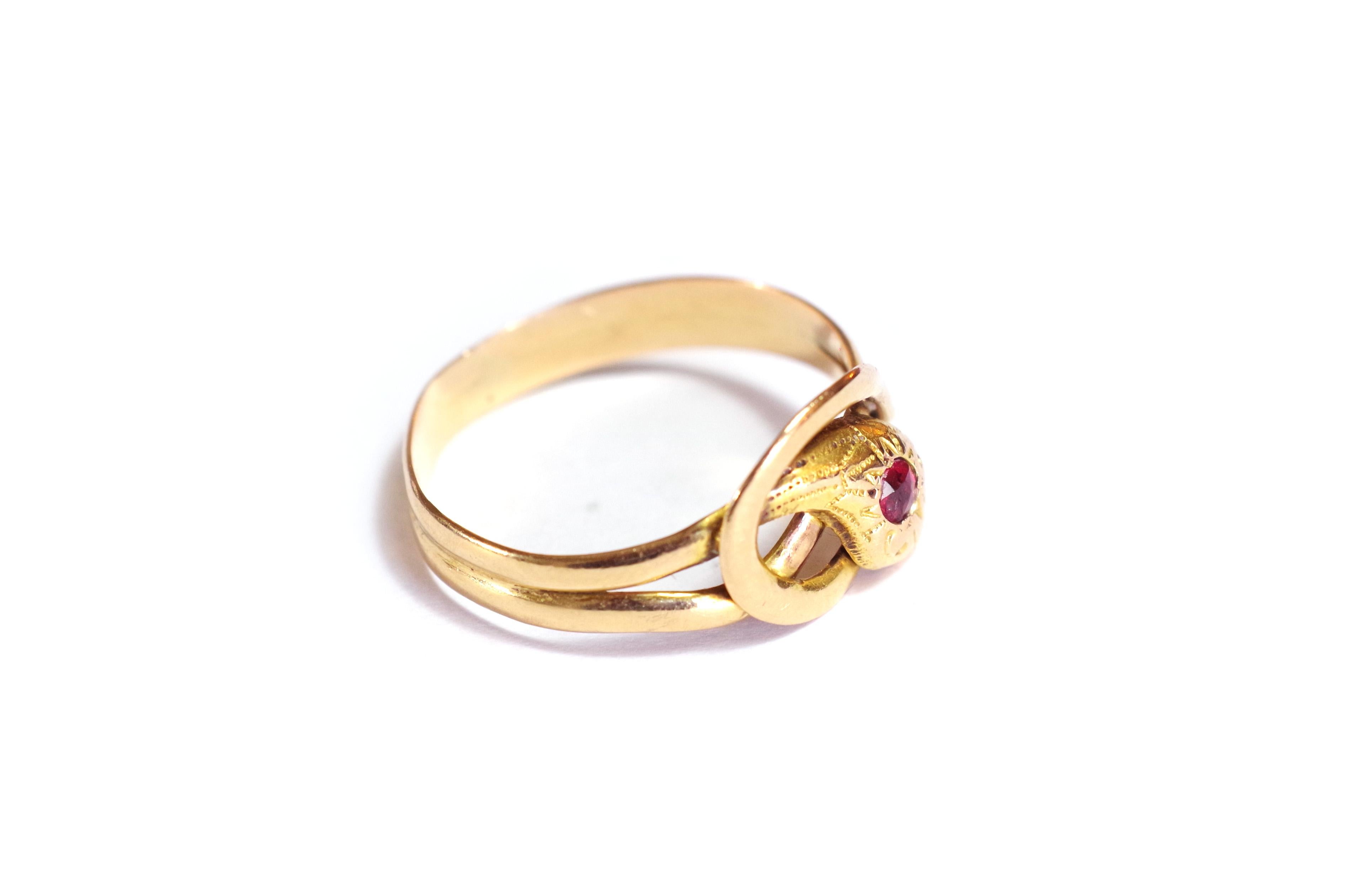 Victorian snake garnet ring in 18k yellow gold. This ring takes the form of a snake winding twice around the finger. The head of the snake is decorated with a round red garnet and delicately chiselled with patterns. It rests on the two rows formed