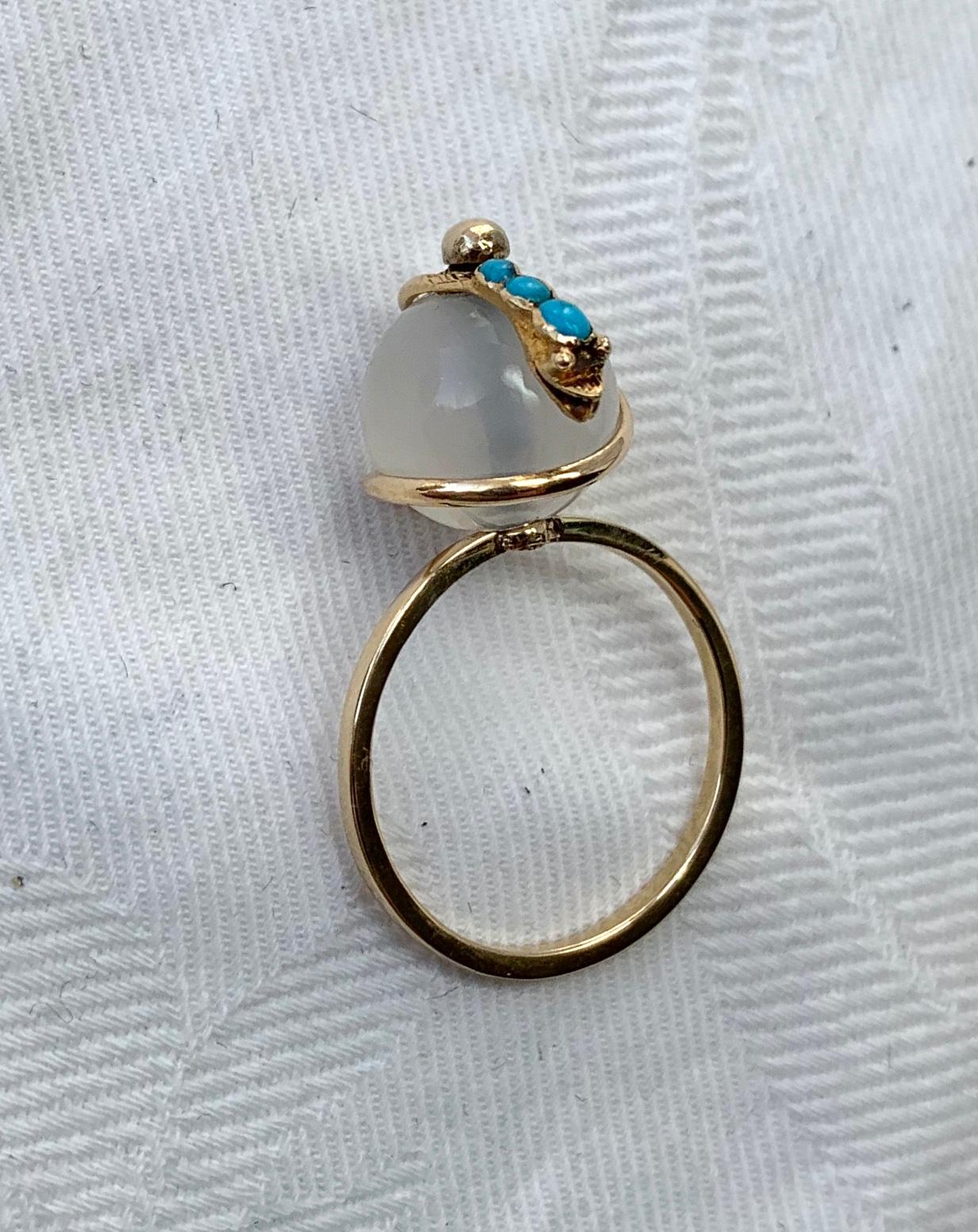 A rare and wonderful antique Victorian Turquoise Moonstone Snake Ring.  The snake is depicted circling the globe or an egg. 
The snake is set with beautiful Persian Turquoise cabochons.  The globe is either moonstone or white agate.  The gold is a