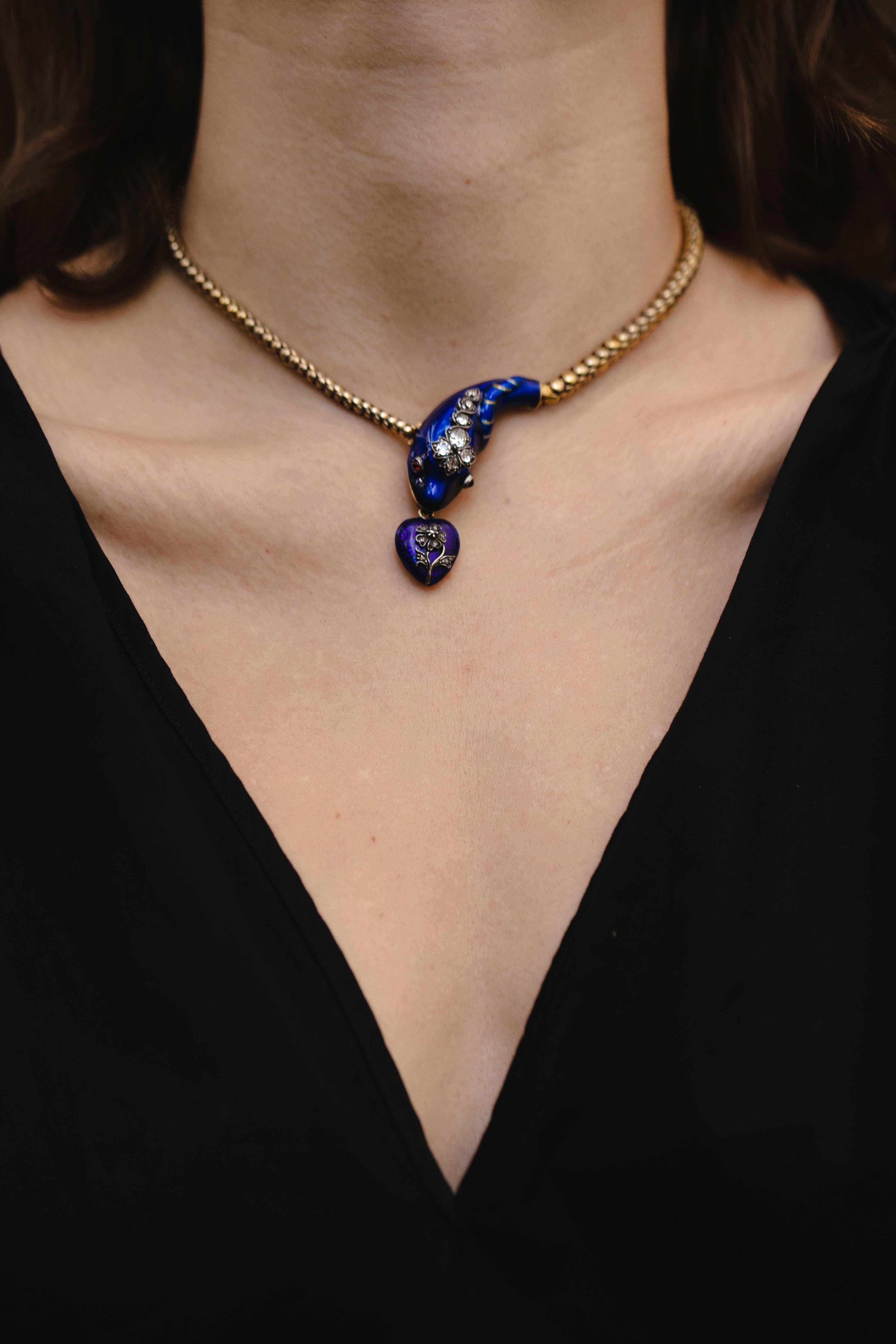 An antique early Victorian gold, fine blue Enamel, necklace & bracelet at the same time. It is designed as an intertwined serpent with gold, and blue enamel, an old mine Diamond-set head with ruby eyes and a blue enamel heart pendant with a locket
