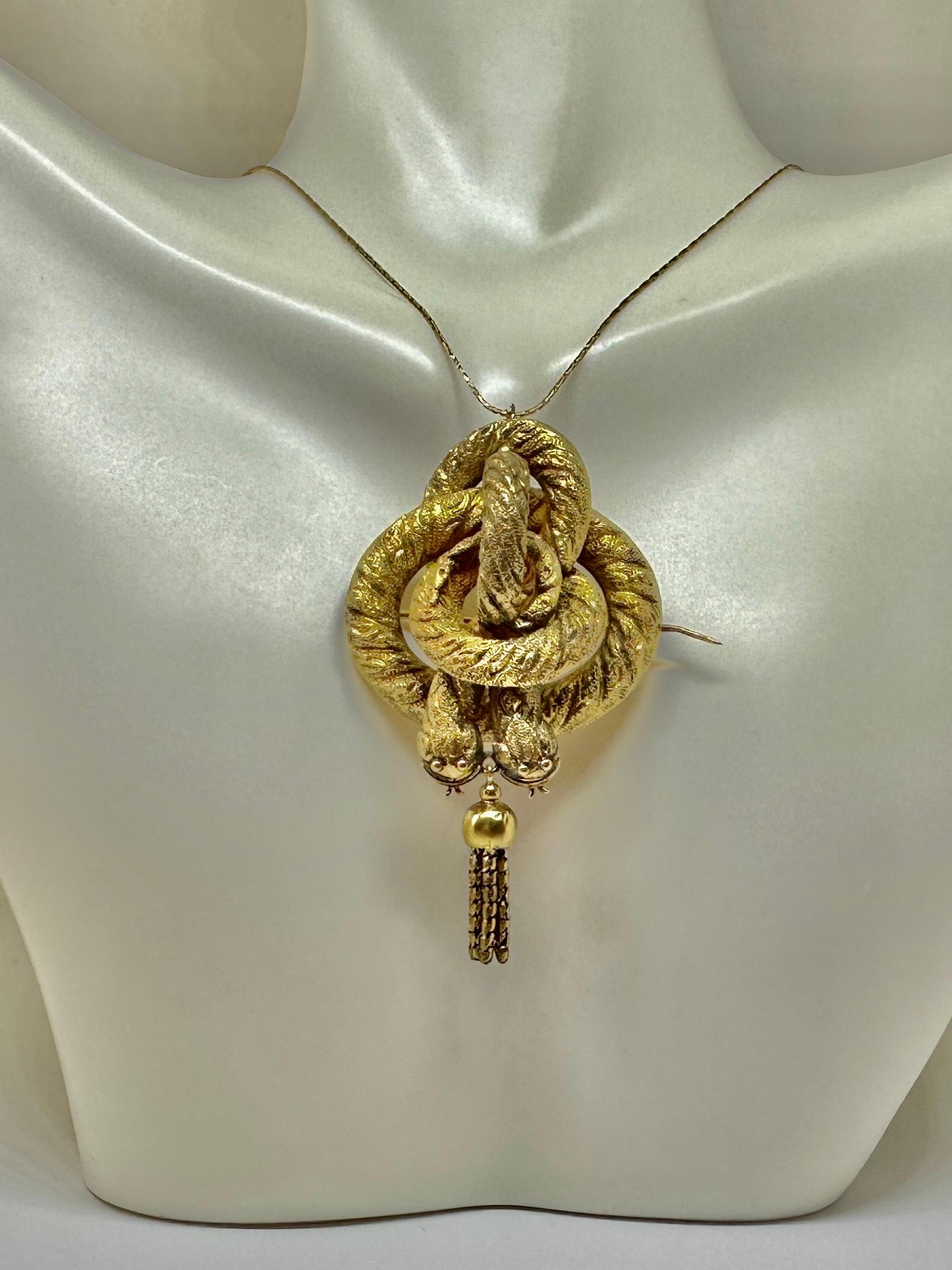 Indulge in a very rare antique Victorian Snake Pendant or Brooch depicting two entwined snakes or serpents.  The snakes are beautifully created in 14 Karat Gold.  The snakes are coiled around each other in a deep engraved repousse design.  A fringed