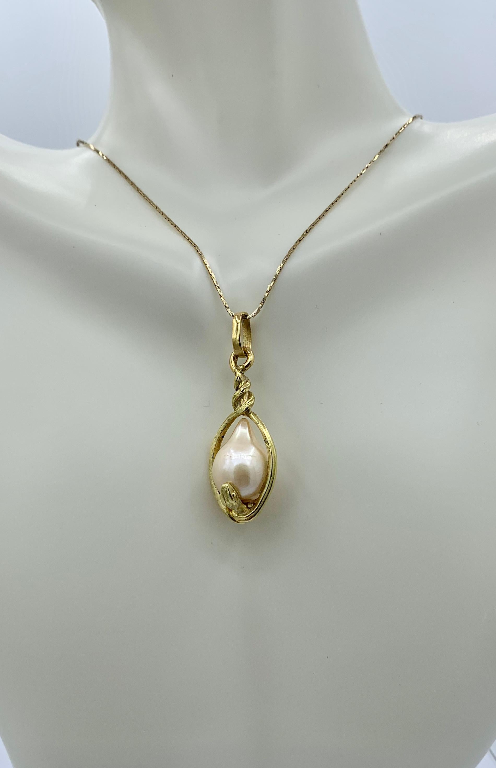 This is a rare antique Victorian Two Snake Pendant Necklace depicting a snake or serpent wrapped around an egg or globe.  The snake pendant is beautifully created in 14 Karat Yellow Gold with a high carat gold wash on top of the 14 Karat Gold as was