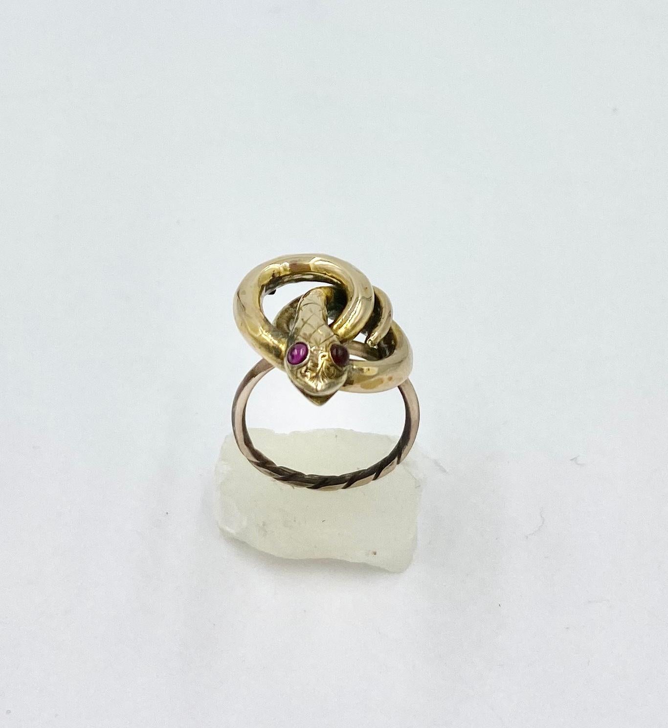 A rare and wonderful antique Victorian Snake Ring with two Bohemian Garnet Eyes in 10 Karat Gold.  The stunning fully modeled three dimensional snake is depicted coiled around itself and raising its glorious head.  The wonderful head has an open