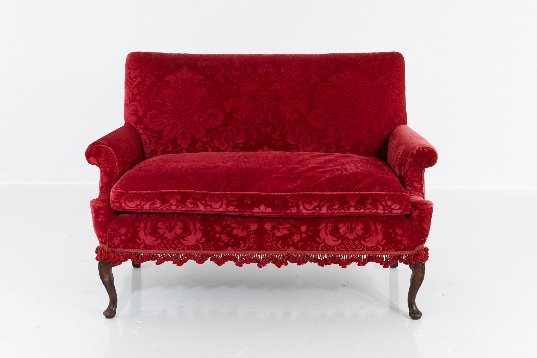 Late 19th century Victorian two-seat sofa with scrolled arms, a red embossed mohair upholstery with an ornamental acanthus pattern and a decorative tassel bordure, mounted on capriole legs.
The sofa is in a very good condition, very comfortable and